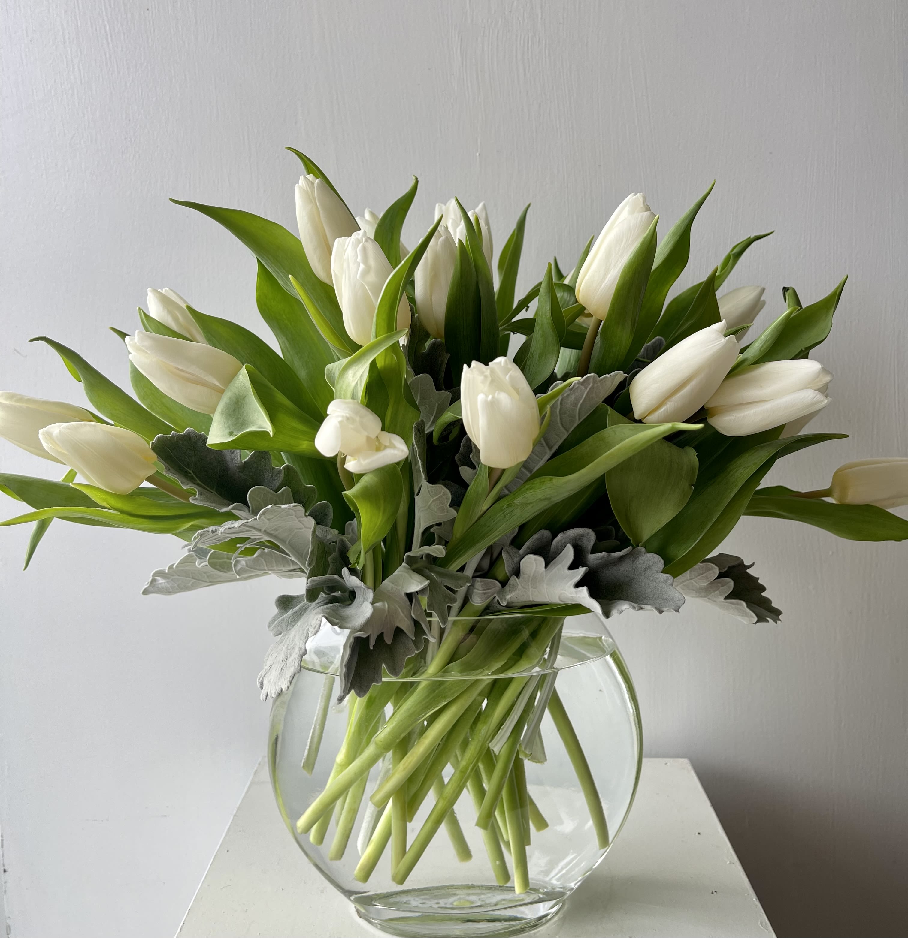 White Tulip Elegance - Simple, stunning, and serene — White Tulip Elegance features a clean and graceful display of fresh white tulips arranged in a clear glass vase. Perfect for modern spaces, thoughtful gestures, or understated beauty, this arrangement brings quiet sophistication to any setting.  Designed by Julia’s Floral and available for same-day flower delivery in Dallas, it's a beautiful way to celebrate life’s calm, meaningful moments.