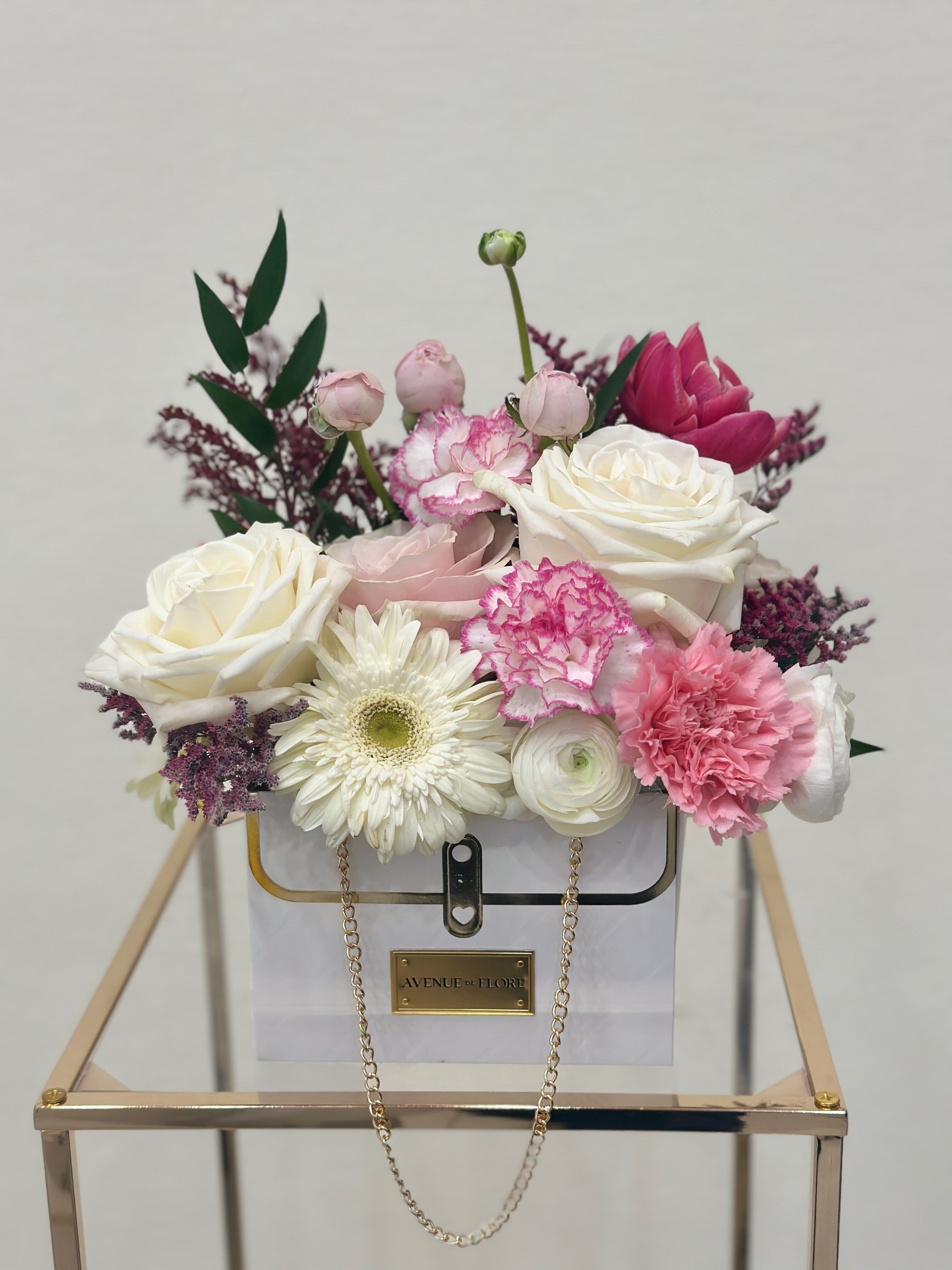 Bag of Love - Introducing our &quot;Bag of Love&quot;, a delightful mix of roses, ranunculus, carnations, tulips, and daisies. A floral arrangement that seamlessly blends fashion with natural beauty. Nestled within an exquisite handbag, each bloom exudes elegance and refinement, making it the perfect accessory for adorning a vanity, dressing up a coffee table, or simply brightening someone's day.  