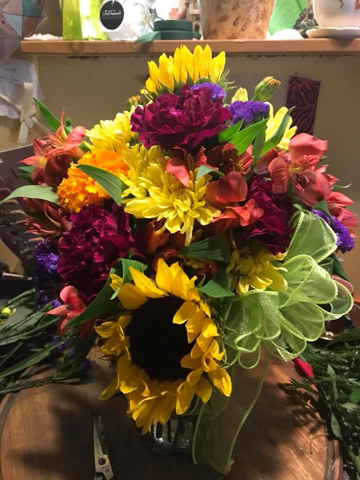 Rainbow Crush Rainbow Crush - Brilliant with color of all shades - yellow sunflowers framed in purples pinks yellow and green blooms - we will use the freshest colors and varieties of the day *ARRANGEMENT IS ONE-SIDED*