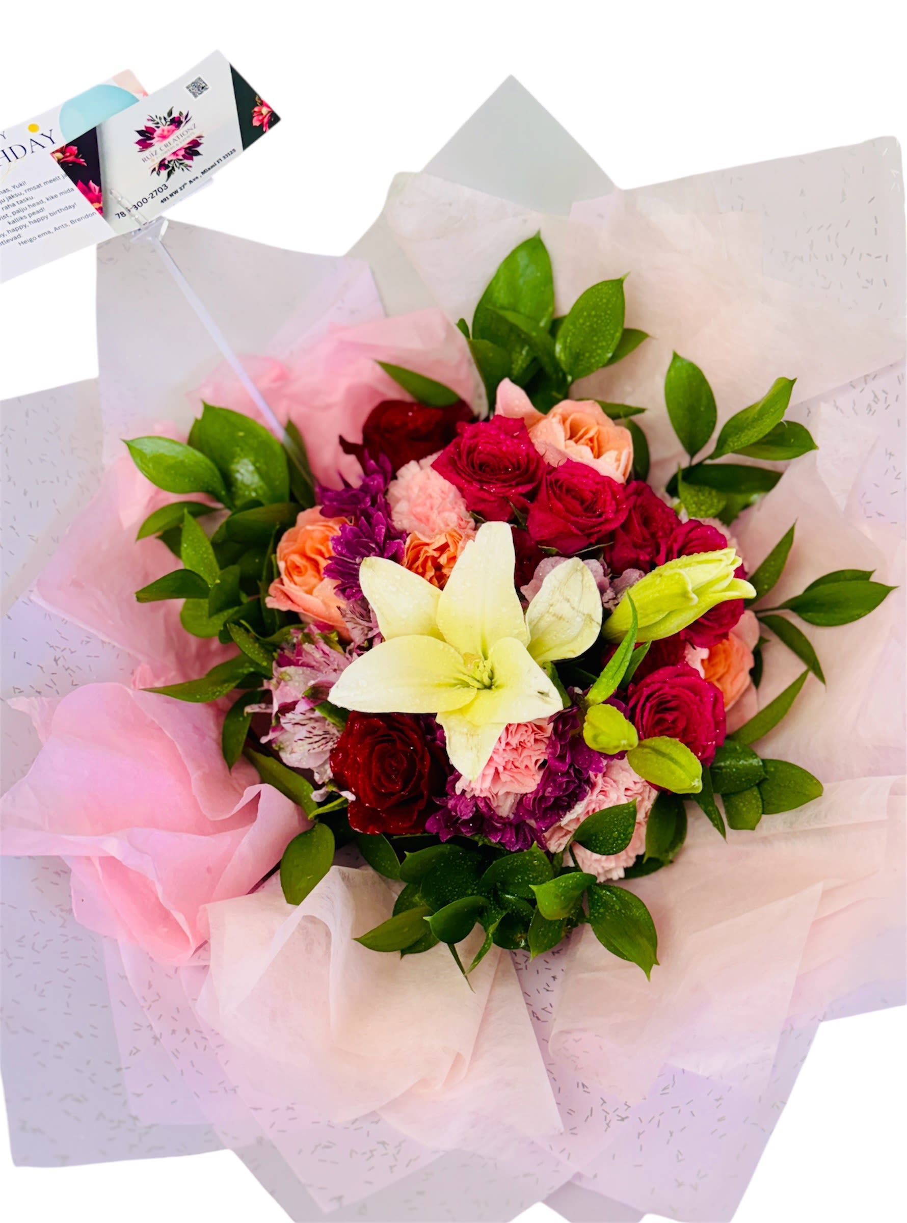 Petal Sonata - This bouquet feels like a romantic melody composed in florals. It features an elegant blend of white lilies, soft pink and red roses, and rich purple chrysanthemums, wrapped in delicate pink and white tissue. The central lily adds an air of sophistication, while the vibrant mix of roses creates emotional warmth. A charming card rises above the arrangement, hinting at a personal message or a poetic dedication—turning the bouquet into a moment of connection.  It’s perfect for anniversaries, romantic gestures, or simply letting someone know they’re deeply cherished.