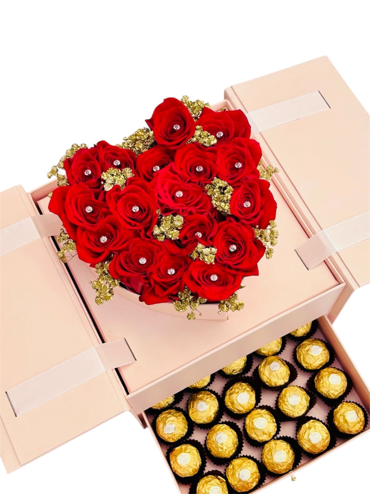 Velvet Luxe Keepsake - This indulgent arrangement feels like a love letter wrapped in velvet and gold. Nestled within a blush pink gift box, the rich bouquet of red roses sparkles with pearl accents at each bloom’s heart, encircled by elegant golden detailing. Below, a drawer brimming with Ferrero Rocher chocolates adds a layer of sweet decadence, making this the ultimate expression of romantic luxury. Every element—from the ribbon closure to the lavish textures—tells a story of affection, thoughtfulness, and celebration.