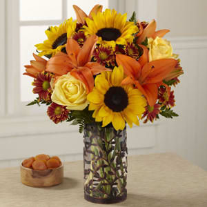 You're Special Bouquet - Make any fall occasion extra special with a bouquet that gorgeously captures the sunny essence of a golden walk in an autumn wood. Some of the season’s sunniest blossoms –sunflowers, yellow roses and spicy orange Asiatic lilies_are beautifully combined with burgundy daisy pompons in a hand-arranged bouquet that evokes dreams of a weekend in the country. The glass pillar vase, encased in a metal sleeve of lacy forest silhouettes, makes a sophisticated setting for this evocative bouquet. It makes a sensational birthday, anniversary or get-well gift_ a delightful way to say “thank you” to a holiday host.