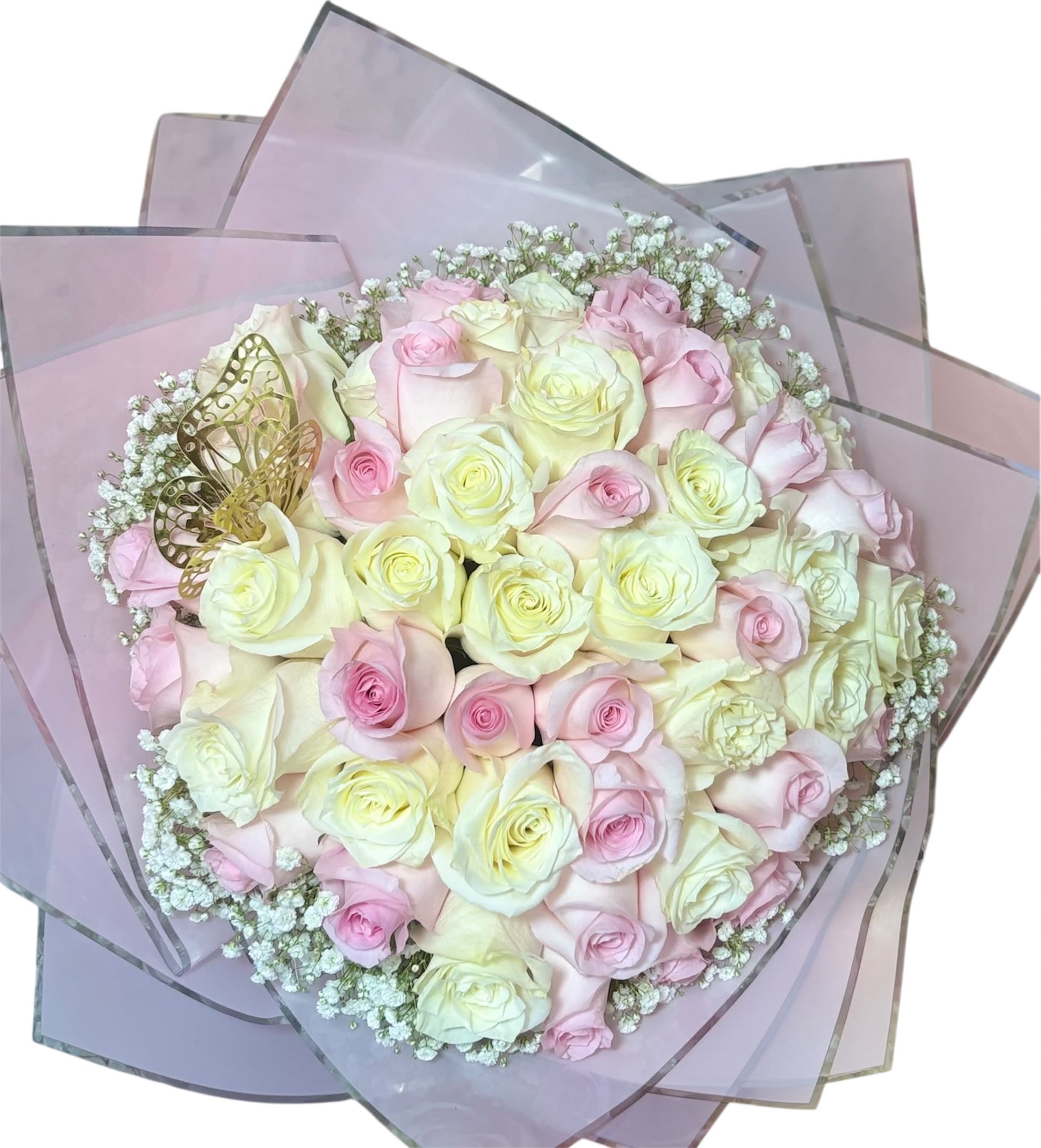 Cotton Candy  - This delicate arrangement feels like a soft embrace captured in florals. Featuring creamy white and blush pink roses nestled in a circular bloom, it's gently accented with baby's breath and translucent pink wrapping that adds an airy elegance. A golden butterfly ornament hovers among the roses like a gentle whisper—symbolizing transformation, hope, and beauty. It's a bouquet that speaks tenderly, perfect for weddings, anniversaries, or heartfelt gestures of admiration.