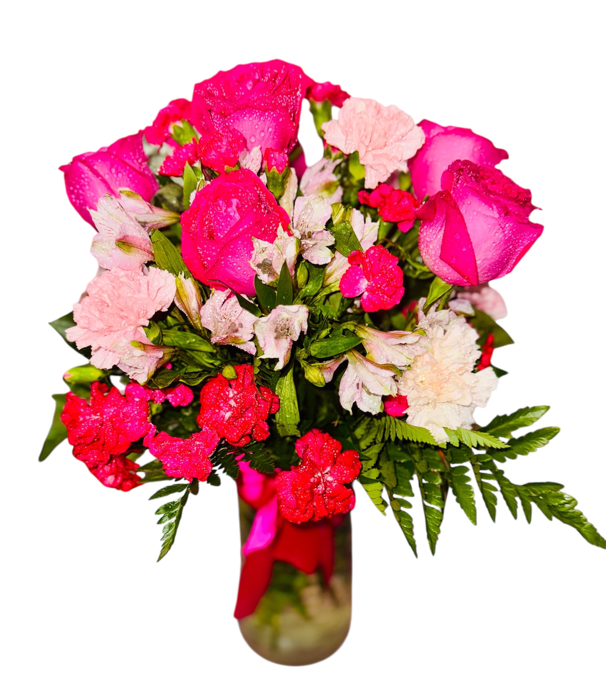 Petal Dew Symphony  - This dewy and delicate bouquet is a symphony of soft romance and natural charm. Bright pink roses mingle with ruffled light pink carnations and petite red blooms, each kissed by droplets of water that catch the light like morning mist. The lush green foliage provides an earthy contrast, while the pink ribbon tied around the vase adds an elegant finishing touch. It's a composition that feels both fresh and intimate—ideal for expressing appreciation, admiration, or gentle affection.