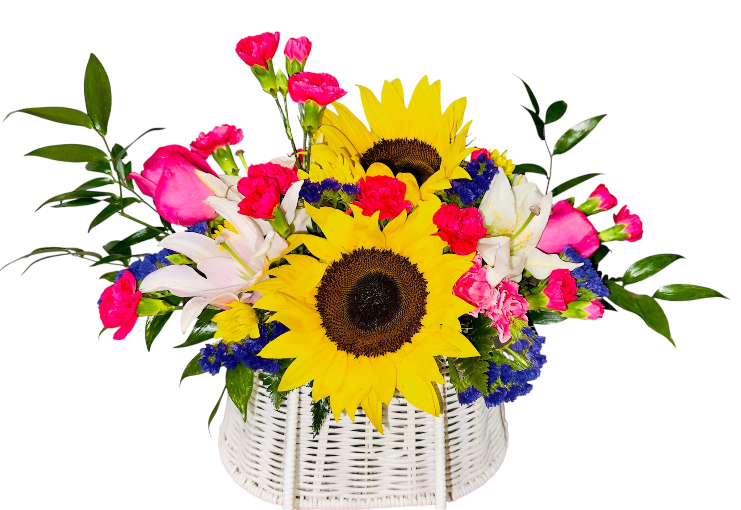 Princess  Basket  - This vibrant arrangement feels like a joyful melody played in petals. Two bold sunflowers with rich dark centers sing the high notes of warmth and cheer, surrounded by a chorus of delicate pink roses, soft carnations, white lilies, and tiny blue blossoms. Nestled in a white wicker basket, the bouquet harmonizes brightness and softness, making it ideal for celebrations, housewarmings, or tender thank-you moments. The palette dances between rustic charm and polished elegance, like nature’s way of composing a heartfelt symphony.