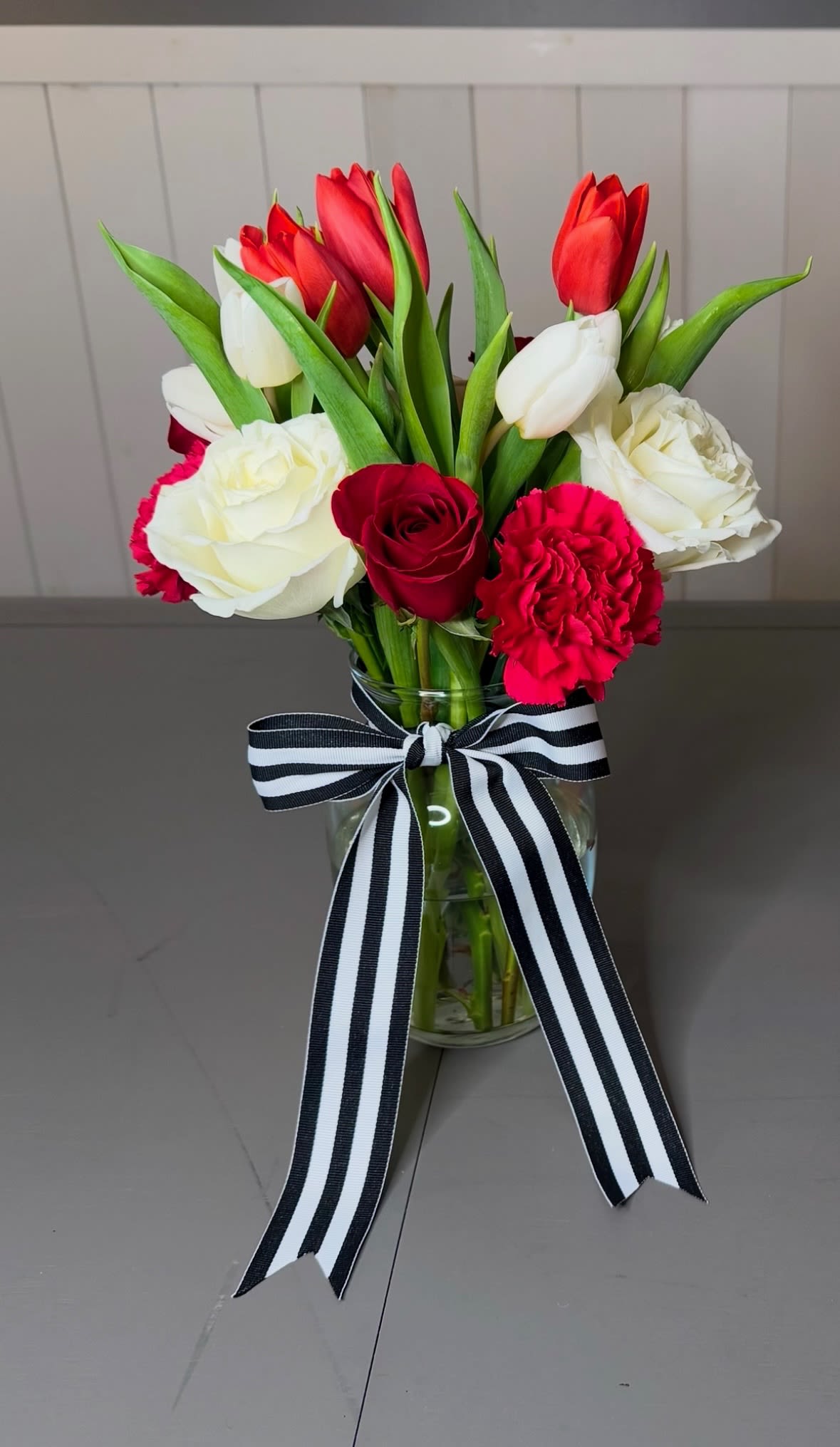 Tipperary Hill Hello - This is the perfect bouquet to send your gesture of love.  A mix of Roses, Tulips and Carnations.  Pictured here in Red and White - but you can specify which color palette you would prefer.
