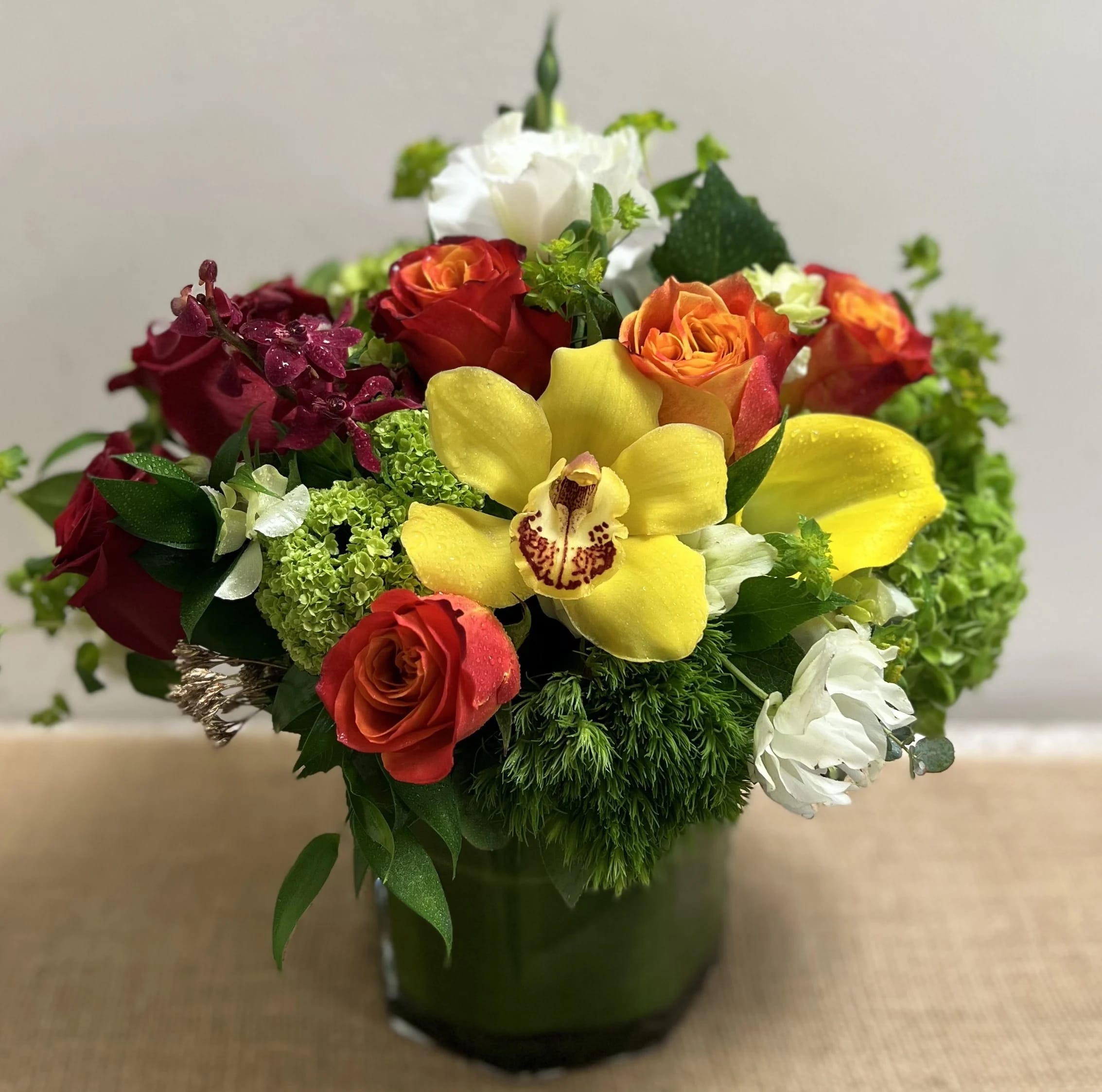 Make a Happy Day Make a Happy Day - A beautiful colorful arrangement consisting of roses, hydrangea, cymbidium orchid glass vase. This versatile arrangement can be enjoyed anywhere.