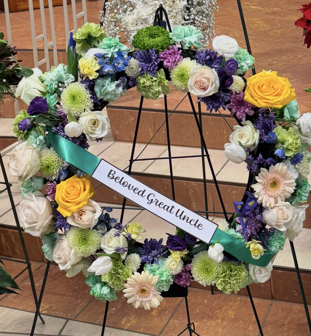 Treasured Tribute Wreath - This wreath is a perfect way to send a tribute for a loved one's service.   Please allow 36 hours for delivery. Alternatively, for a heaven anniversary, we can deliver directly to one of our local cemeteries right to your loved one.  Please specify where your loved one is located.  We will use the freshest and most colorful flowers available and in season and as always, send you a Bloomsnap or picture once delivered.  Also available as a Headstone Saddle.