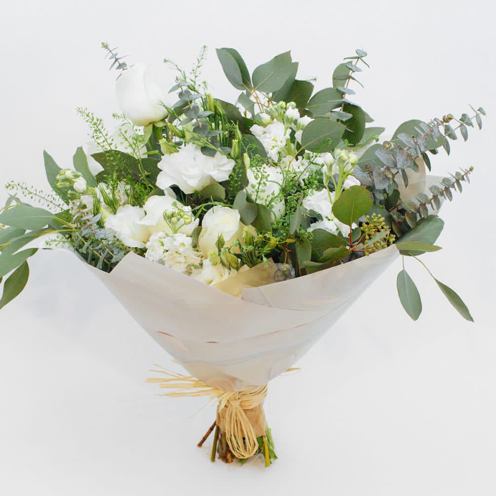 White Essence  - WHITE MIXED FLOWER BOUQUET WITH VENDELA ROSES AND EUCALYPTUS   Fresh and dreamy. A beautiful, wild bouquet in silver, green and white. This gorgeous design stars Vendela roses in a delicate ivory shade. These roses have very large heads that open into a cup-shaped bloom with slightly curled edges. Vendelas are one of our favorites!  The bouquet also mixes frilly, fragrant white stock with romantic white lisianthus flowers and varieties of silvery eucalyptus that gives the bunch a free-flowing, soft style.  These flowers are perfect for people with a romantic soul.  Send this beautiful white bouquet to say happy birthday, congratulations or thank you. They also make exquisite sympathy flowers.  Why not add a greeting card, bunch of local dried lavender or quality handmade candle to match the occasion or personality?  White Essence features: ·        Ivory Vendela roses ·        Fragrant white stock ·        Romantic white lisianthus ·        Spiral eucalyptus ·        Coin plant stems ·        Silver dollar eucalyptus ·        White paper gift wrap  SIZE: The STANDARD flower arrangement is approximately 14” height and 14” width.   ALLERGY ADVICE: This design has low pollen and a moderate-strong fragrance.     FAQ Q: What time will my flowers arrive and what if no-one is there to accept them? A: Excellent question! We’re unable to provide or guarantee specific delivery times. All our flowers are delivered anytime between 9-5pm, with exception to Sympathy designs for a funeral service. For full details around our delivery process and timings, please see our Terms and Conditions. Q: What days do you deliver flowers? A: All our flowers are available for San Francisco and Daly City delivery seven days a week, between 9am-5pm. Q: May I order for the same day delivery? A: Yes, same day deliveries are available if you place an order before 1pm. Q: May I request to change the design a bit? A: Yes, please make a note in the SPECIAL INSTRUCTION box when you place your online order. We will do our best to follow them. Q: Will my flowers look exactly as what is pictured? A: Depending on the season, colors or shades may vary. Sometimes we need to substitute flowers due to seasonal availability, but they’re always substituted for the same or greater value.   Ready to bring floral beauty into someone’s world with this fresh white bouquet? Order this gift online now or give us a call on (415) 752-2060 if you have a question or special request. 