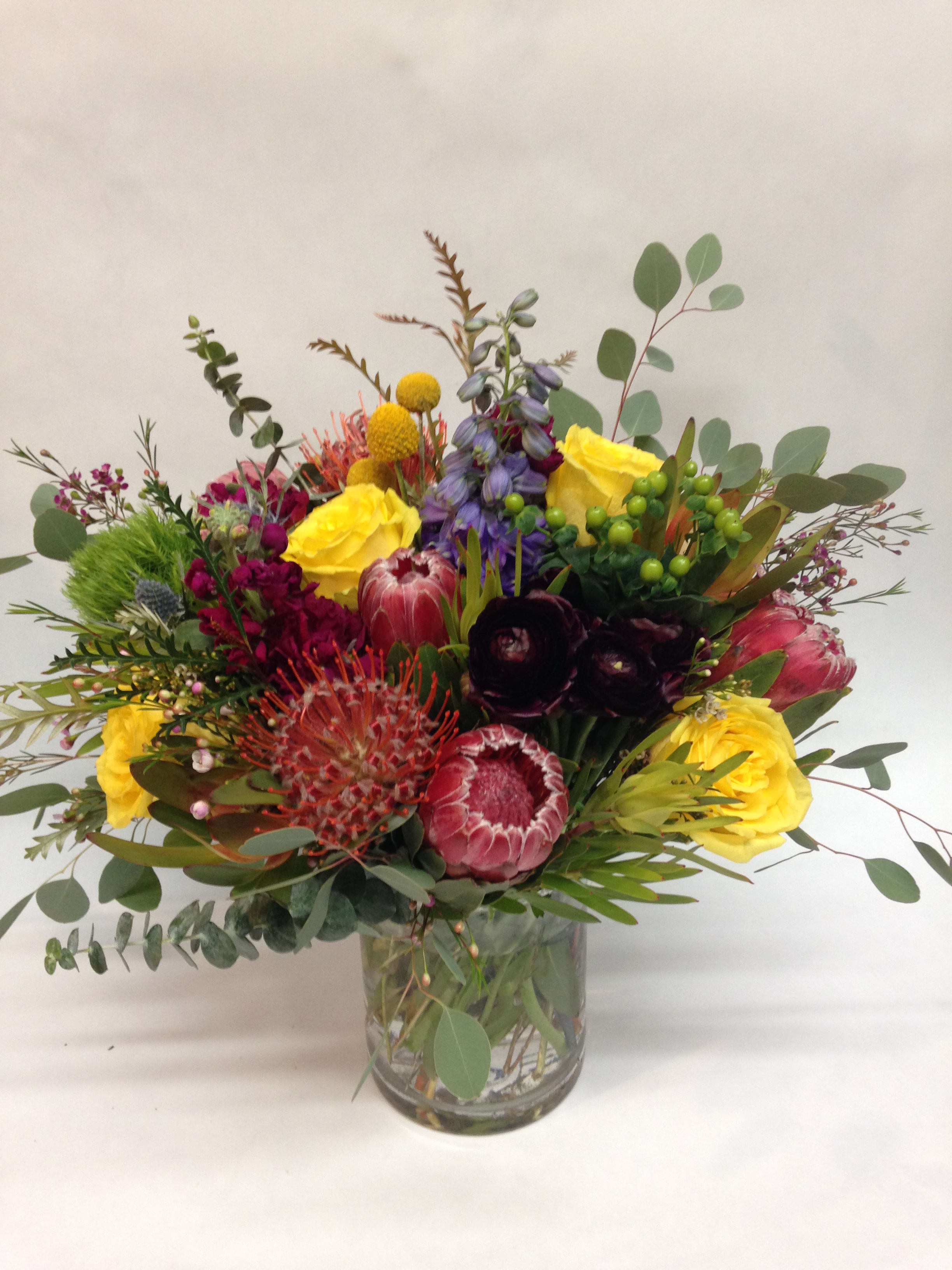 Rustic Elegance. (LONG LASTING). Rustic Elegance. (LONG LASTING). - This textural arrangement comes complete with pin-cushions proteas, queen proteas, roses, stock, dianthus, belly balls, belladonna, hypericum, sea thistle, safari branches, wax flower and seasonal greenery. (Some flowers may be subject to change depending on the season. We will contact you with available flower substitutions; please contact us with specific questions if you are concerned with flower availability, thanks!) Featured arrangement: $135.75 (Regular Price) PS we can sub yellow roses for orange or red for thanksgiving look. please let us know . Thank you.