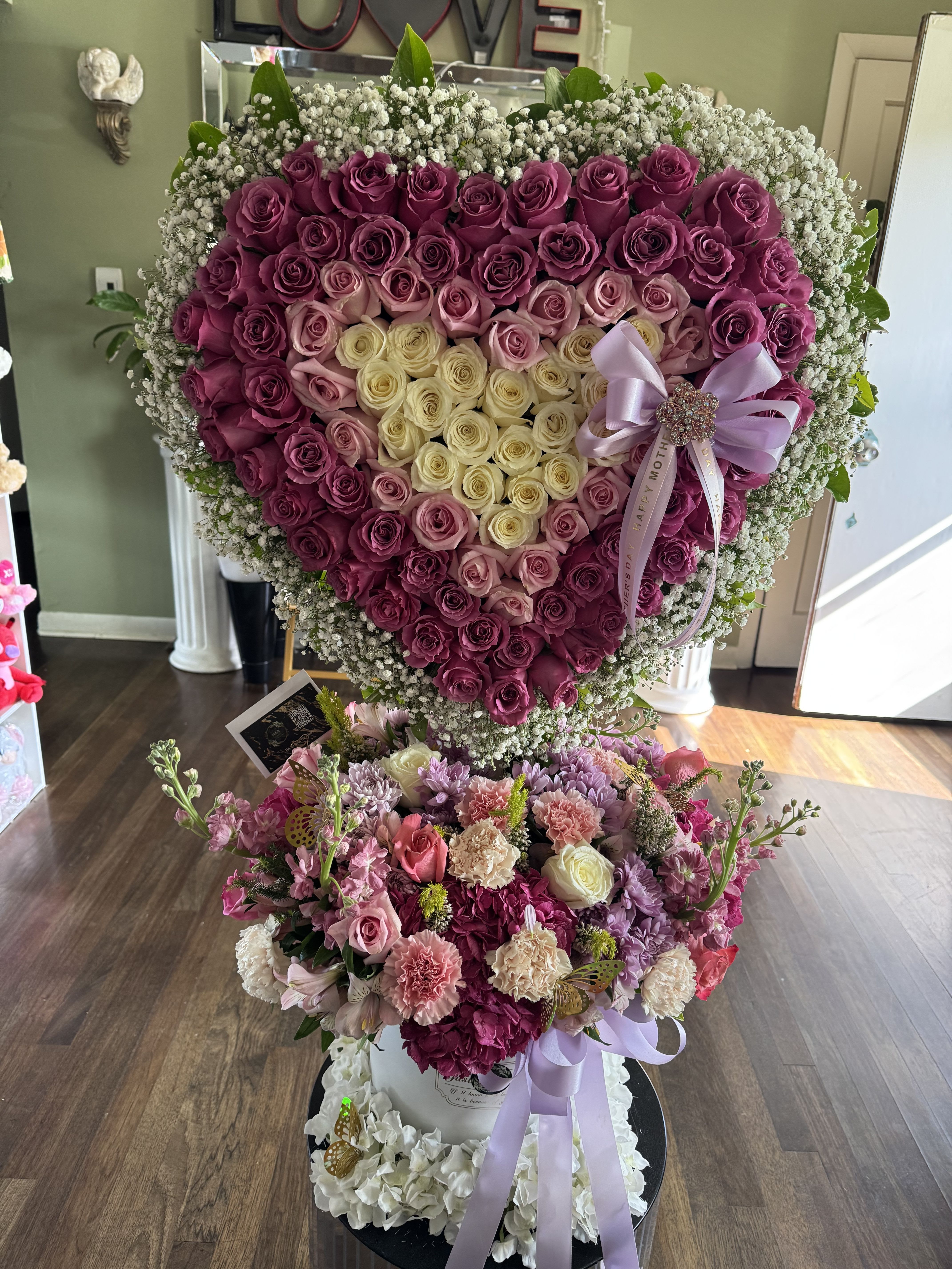 Sweet romance heart floral arrangement Sweet romance heart floral arrangement - Floral arrangement of our premium line, consisting of heart with 3 shades of roses in gradient, white, light pink and hot pink, with baby breath edges and bottom with assorted flowers, stock, roses, carnations, mums, lisianthus and aster lilac, in high box with double bow detail and glass brooch of pearls and decorative butterflies.available every day. Arreglo floral de nuetra linea premium ,comformado por corazon con 3 tonos de rosas en desgradacion , blanco, light pink y hot pink , con bordes de aliento de bebe y parte baja con flores variadas ,stock , rosas , claveles , mums , lisianthus y aster lila , en caja alta con doble detalle de lazo y broche de cristal de perlas y mariposas decorativas .disponible todos los dias .