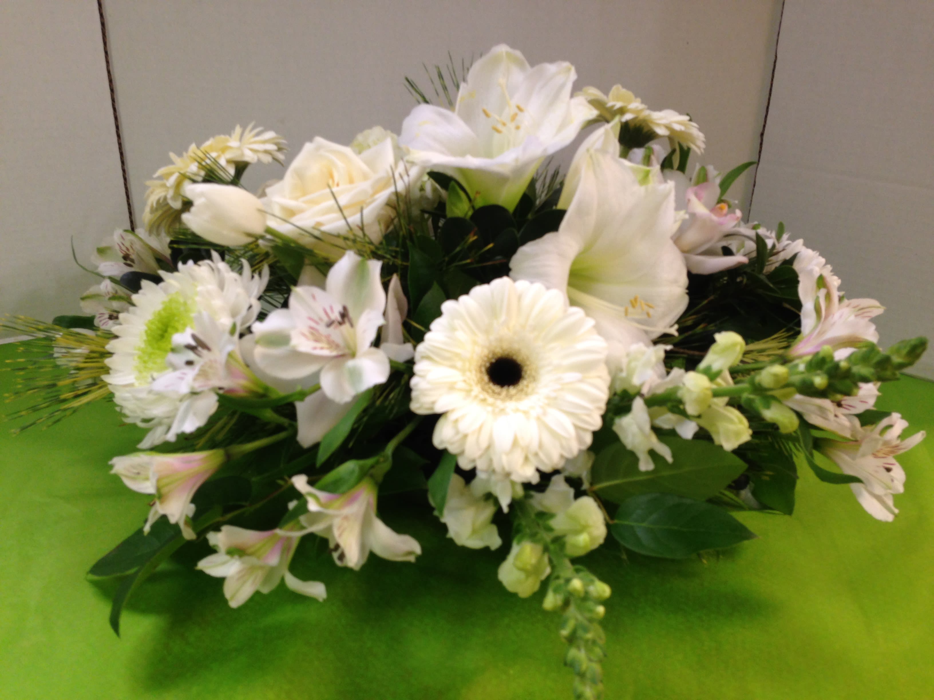 White Seasonal Centerpiece White Seasonal Centerpiece - Roses, Lilies, Amarytlis(Seasonal), Gerbera Daisies, Alstroemeria, Snaps, Seasonal Fancy Greens