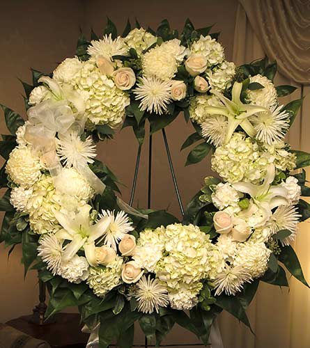 White Garden Mix Funeral Wreath White Garden Mix Funeral Wreath - This wreath, featuring a mixture of white roses, spider mums, lilies and other seasonal flowers is created for use at a funeral wake, cremation or memorial service. Approximately 27" During the order process, you can indicate where to send the flowers. Order by 10am to ensure delivery for 2pm showings at wakes.
