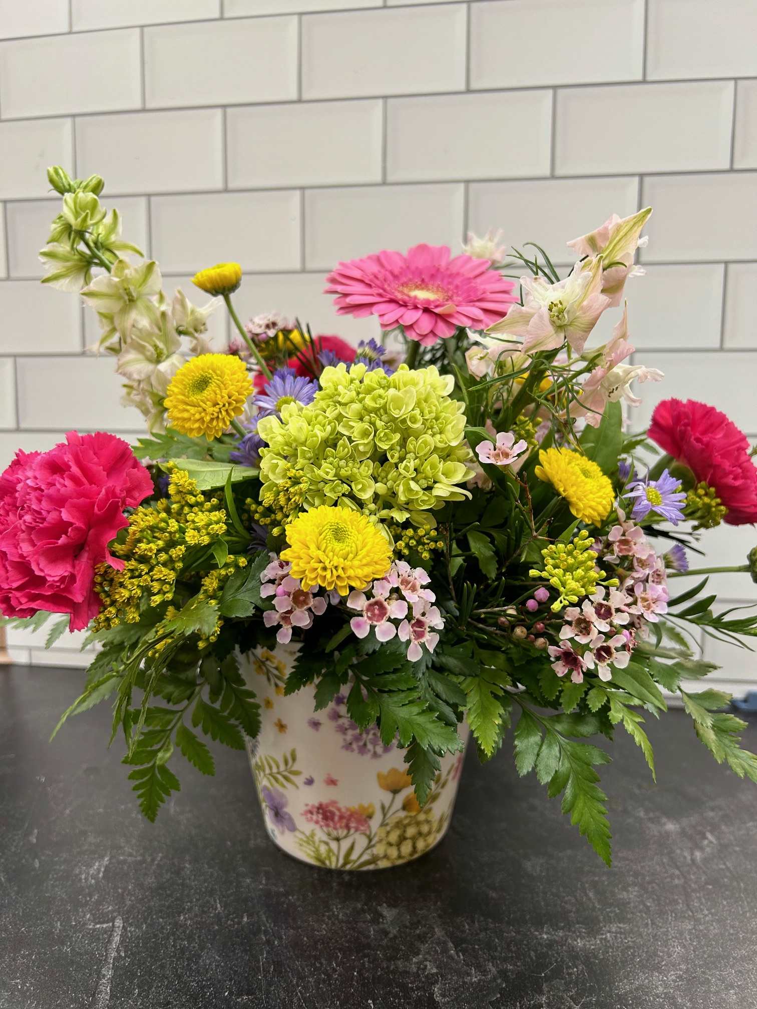 Pretty Posey Pretty Posey - A perfect arrangement for mom, grandma, or your favorite aunt. This fresh arrangement features gerbera daisies, hydrangea, spring asters, larkspur and more! Available to upgrade.