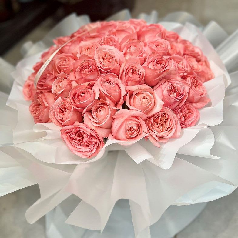Romantic Proposal Rose - A heart-stopping arrangement of lush pink roses, wrapped in layers of soft white like a bouquet dressed for the occasion. “The Promise” is designed for life’s biggest moments—proposals, anniversaries, declarations of forever. It doesn’t whisper. It declares.  For when you want the answer to be yes.