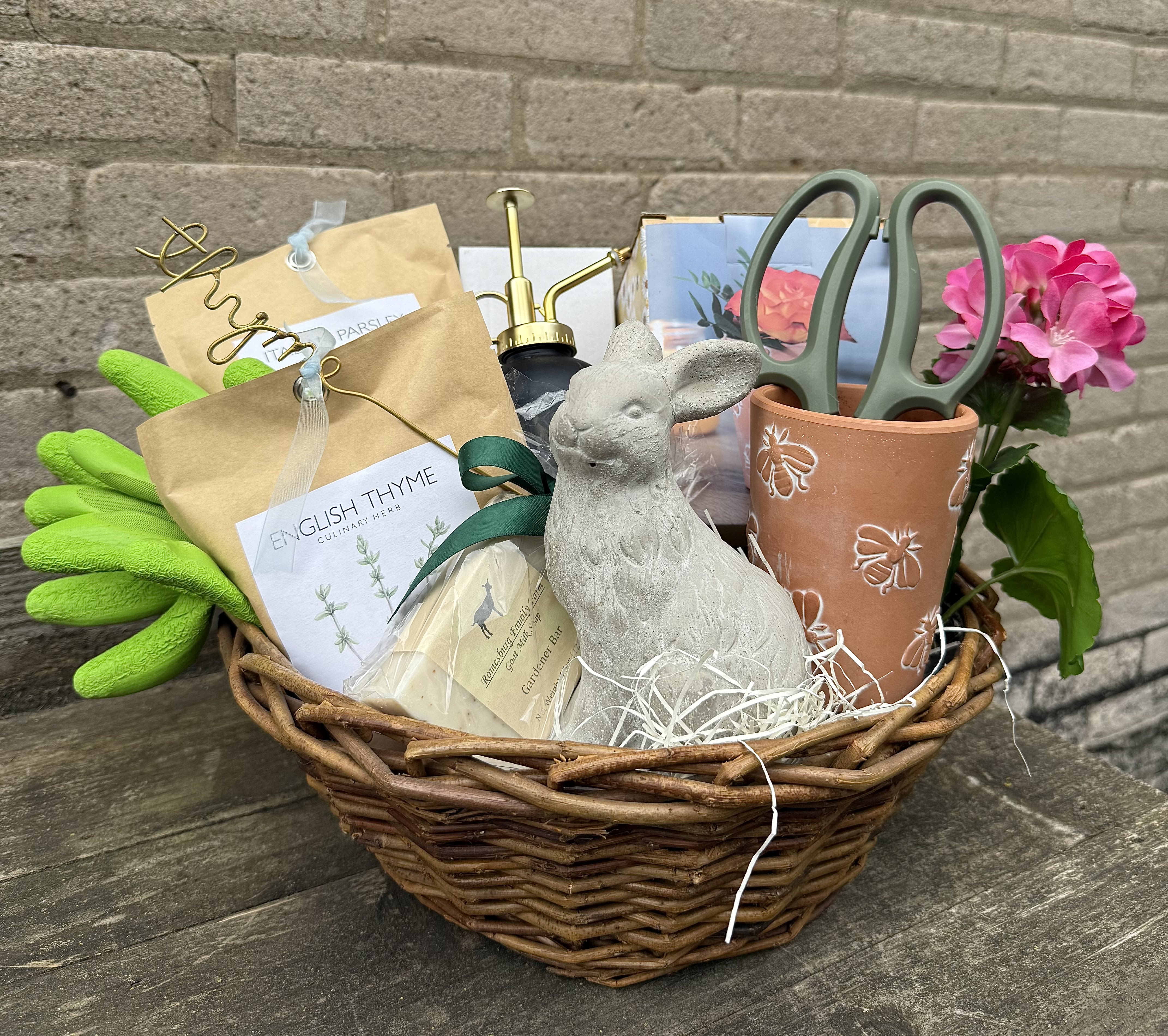 Gardeners Basket - A perfect gift for any time of the year for your special person who enjoys gardening both inside or outdoors! We have tried to make it interesting and fun. We have included wonderful shears which we use in our shop, a great bee terracotta pot, a plant mister, two packets of herbs, a herb marker and a bar of garden soap, garden gloves and of course everyone needs a bunny to display! We will include a blossom and wrap with a bow.