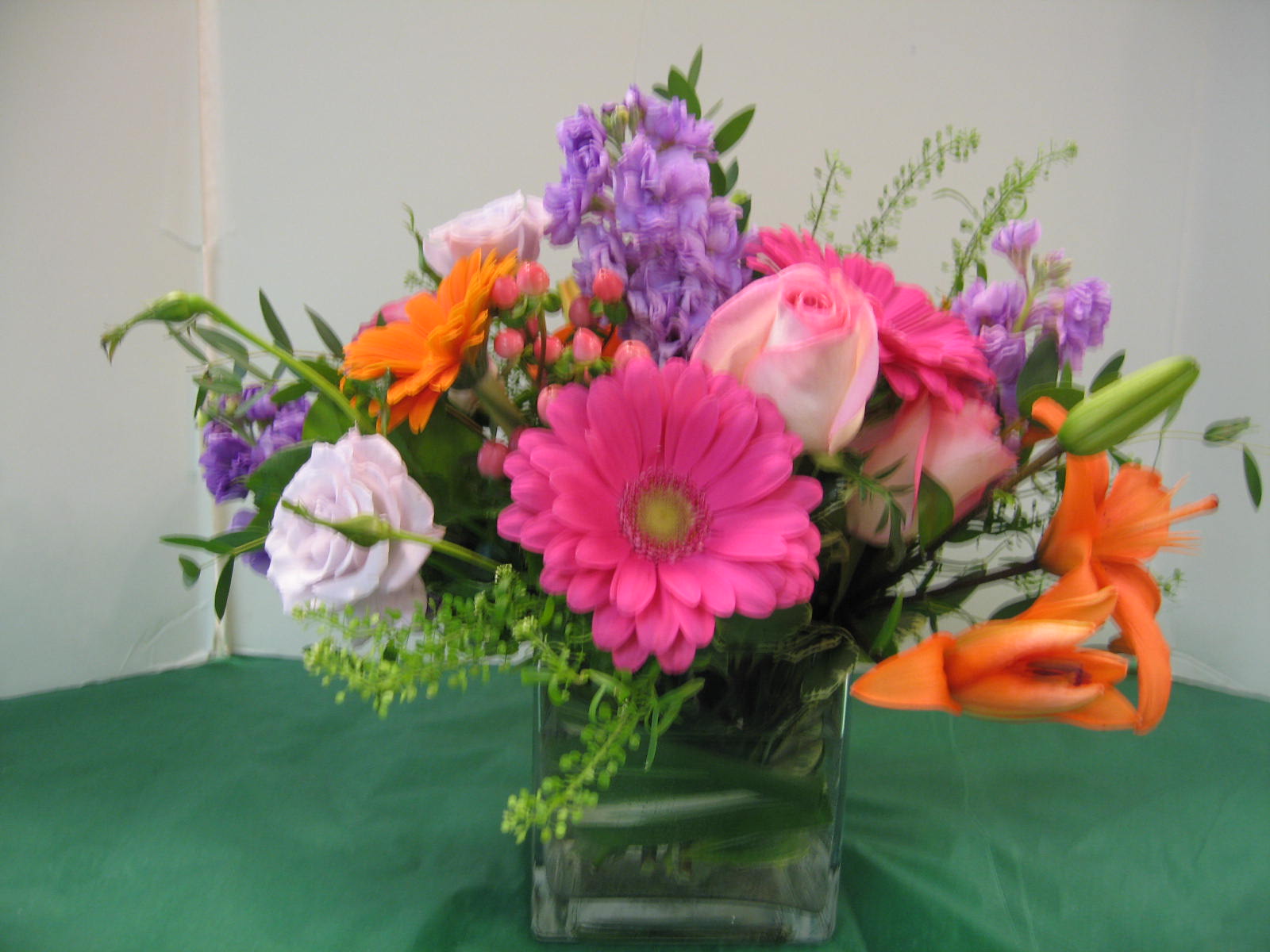 Assorted Flowers (Picture is Deluxe) Assorted Flowers (Picture is Deluxe) - Lilies , Gerbera Daisies , Stock, Roses and Assorted Greens
