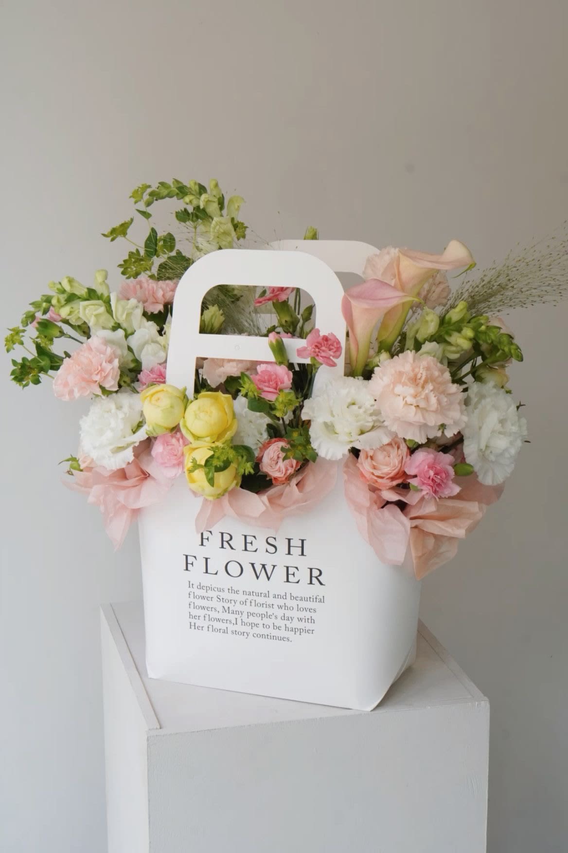 Elizabeth Elizabeth - inglés: A delicate and elegant arrangement designed to brighten meaningful moments. Soft pastel tones and refined textures come together in this signature floral tote, making it the perfect gift to express love, gratitude, or simply bring joy. Each element is carefully selected and arranged to offer a serene, luxurious experience — a true celebration of beauty in bloom.