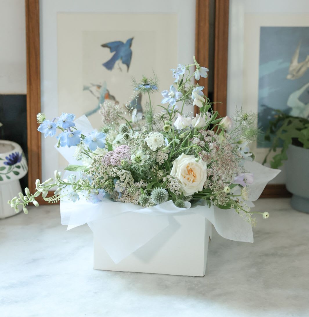 Modern Blues - Elevate the table with a stunning arrangement of our own local flowers. Flowers are cut just moments before arranging to ensure freshness and longevity. Meticulously curated and expertly arranged, each bloom is placed with care to create a modern, airy piece that is sure to impress. 