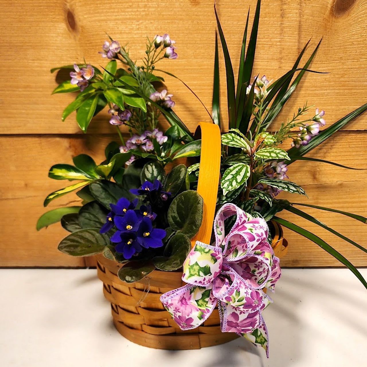Peaceful Wishes Garden - Peaceful Wishes Garden by Savilles Country Florist featuring a gathering of 4&quot; plants accented with silk (artificial) botanical stems and presented in a split wood basket. Plant styles, types and colors may vary from what's shown in the photo due to availability, but presentation will be similar.   Approx. 12&quot; H x 6&quot; W. Simply lovely and perfect to send for all occasions.   PLEASE NOTE: Some flowers, plants, vases and other products pictured are subject to availability, and may be substituted for a similar item if unavailable according to our substitution policy.