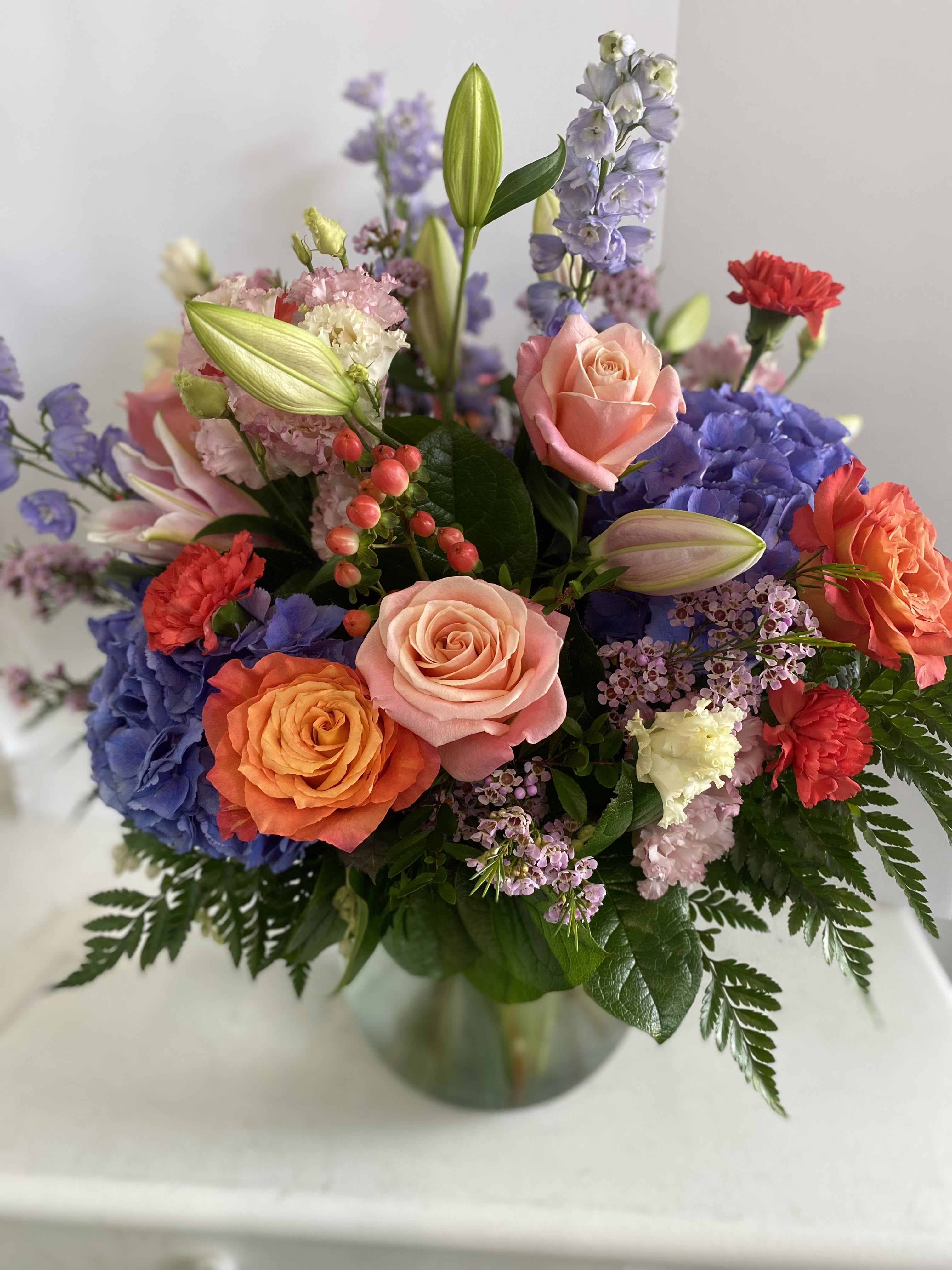 Best Mom Ever!! Best Mom Ever!! - This lively and bold arrangement is a celebration of color! Gorgeous peach and orange roses are complemented by rich blue hydrangeas, soft pink carnations, and delicate lilac wax flower. Fresh berries and budding lilies add texture, while lush greenery completes the look. Perfect for any occasion, this arrangement radiates joy and elegance, making it a beautiful way to express love and appreciation!!