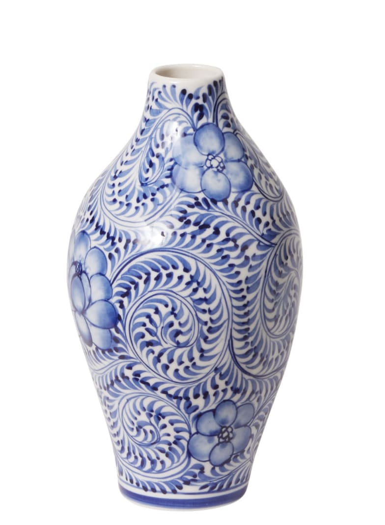 Eleanor Bud Vase - A fresh take on classic chinoiserie, the Eleanor Budvase blends timeless charm with modern functionality. Intricately hand-painted with delicate blue floral motifs on white stoneware, this elegant piece is designed with the floral artist in mind. Its curvy silhouette, tapered neck, and slender 0.75&quot; opening are perfect for showcasing a few thoughtfully chosen stems. Ideal for weddings, dining tablescapes, or cocktail table centerpieces, the Eleanor Budvase adds a touch of vintage sophistication to any setting.  Dimensions: 3.5&quot; x 3.5&quot; x 7.0&quot; Opening: 0.75&quot; diameter Material: Ceramic