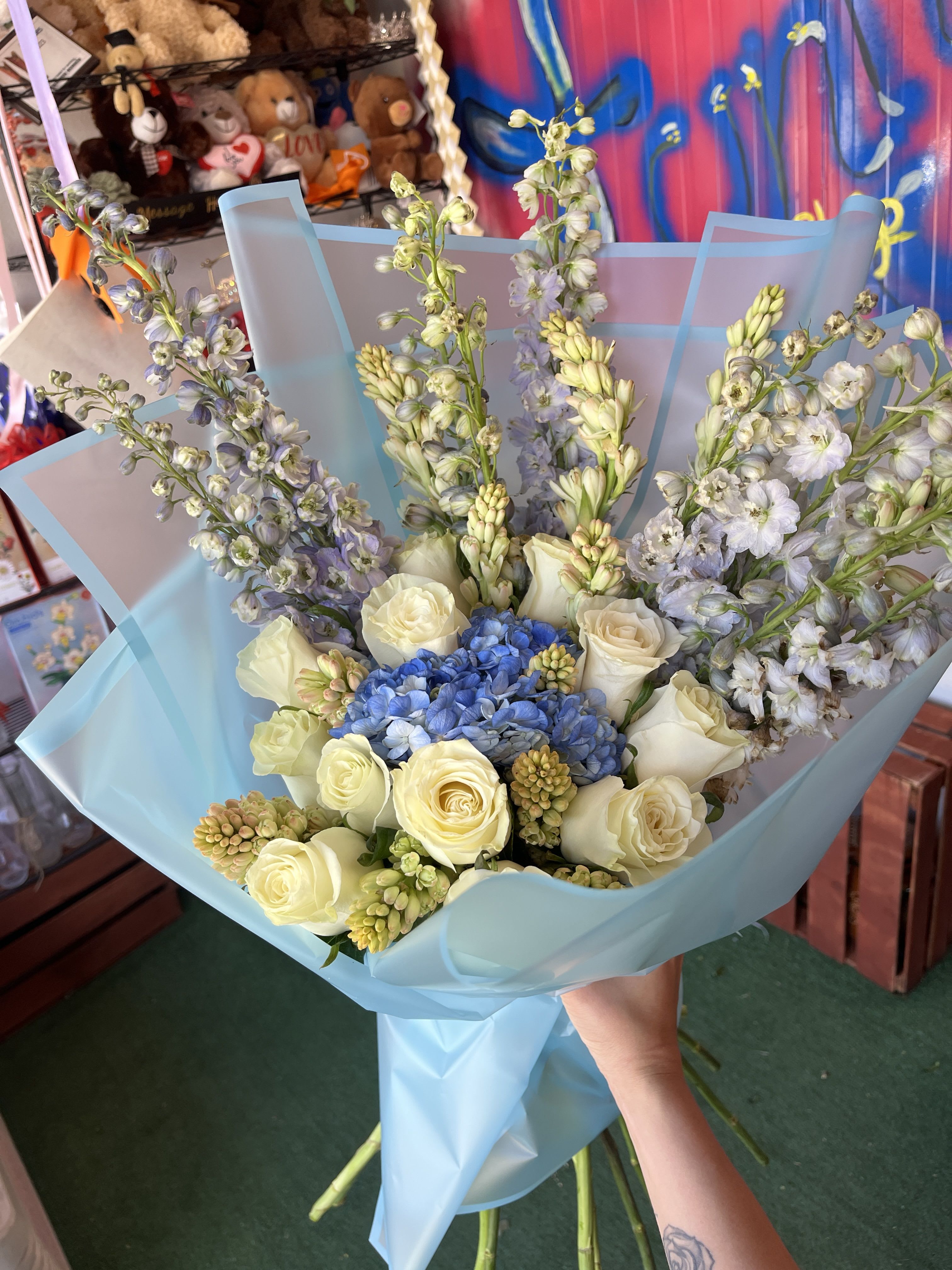 Blue Beauty - mix of tuberose; delphinium; and roses, with a hydrangea in the center