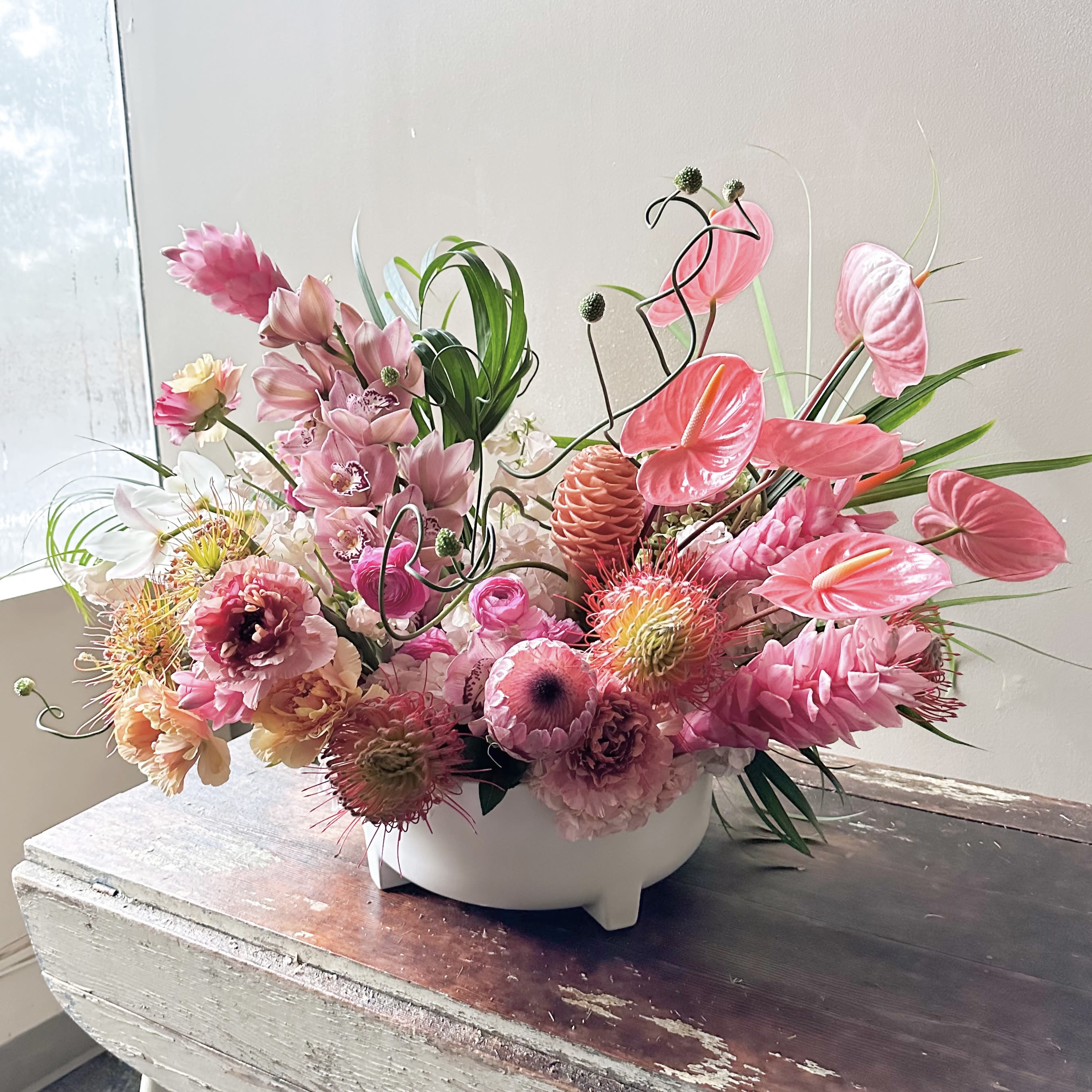 Leve (Gallery Photo) - Send light and love with this modern and artful design in such beautiful coral colors! This harmony of luxurious blooms are just waiting for a butterfly to fly in to complete an experience of a secret tropical garden!