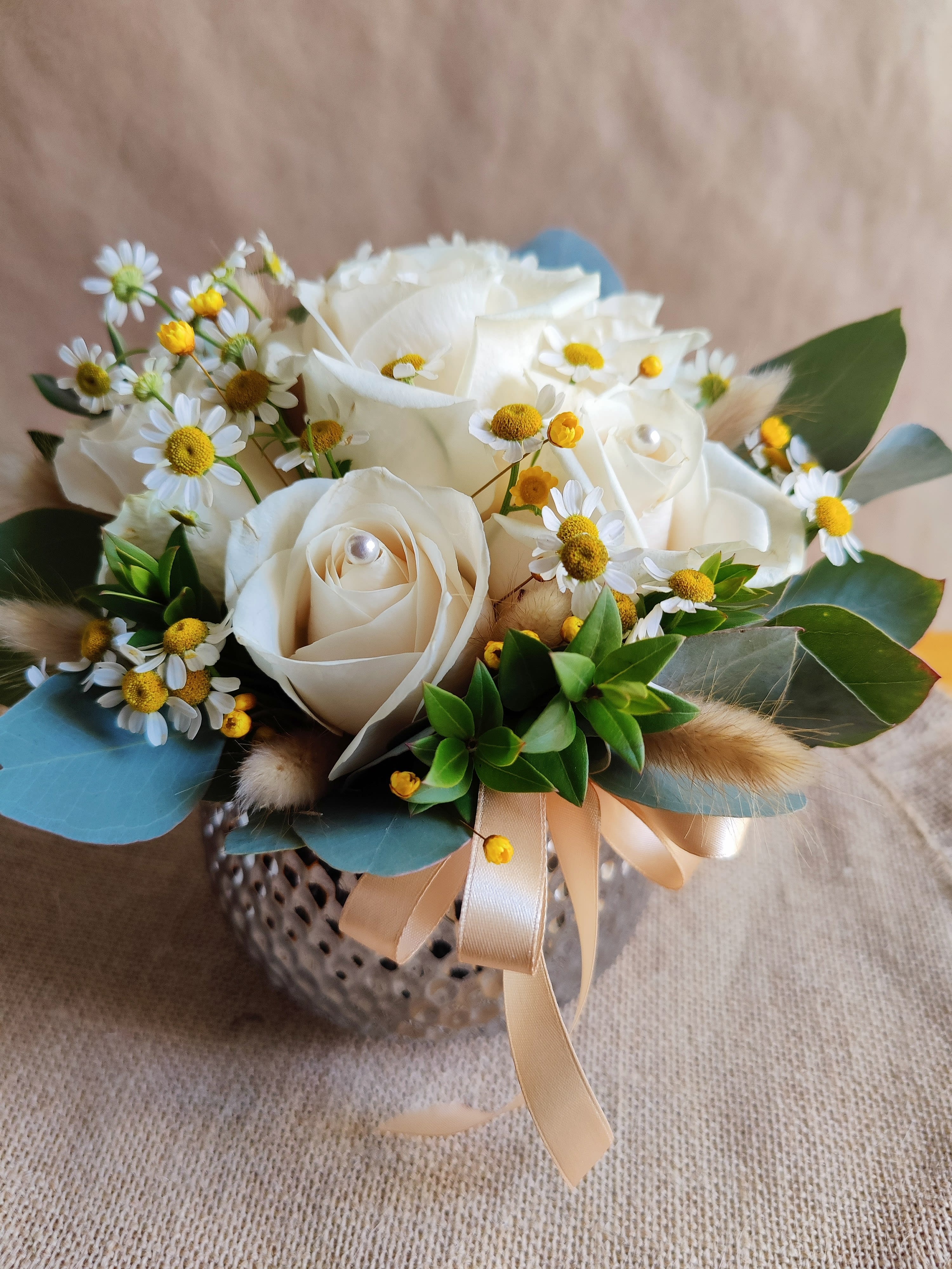Minimalist White Rose Arrangement  - Beautiful  roses arrangement in soft white colors  This beautiful piece is decorated  with fresh quality roses ( 10-12 roses), seasonal foliage,  ornamental chamomile and some  decorative pieces to add more  beauty.  It's Small size  Classic style. It includes a pretty ceramic vase in silver color.