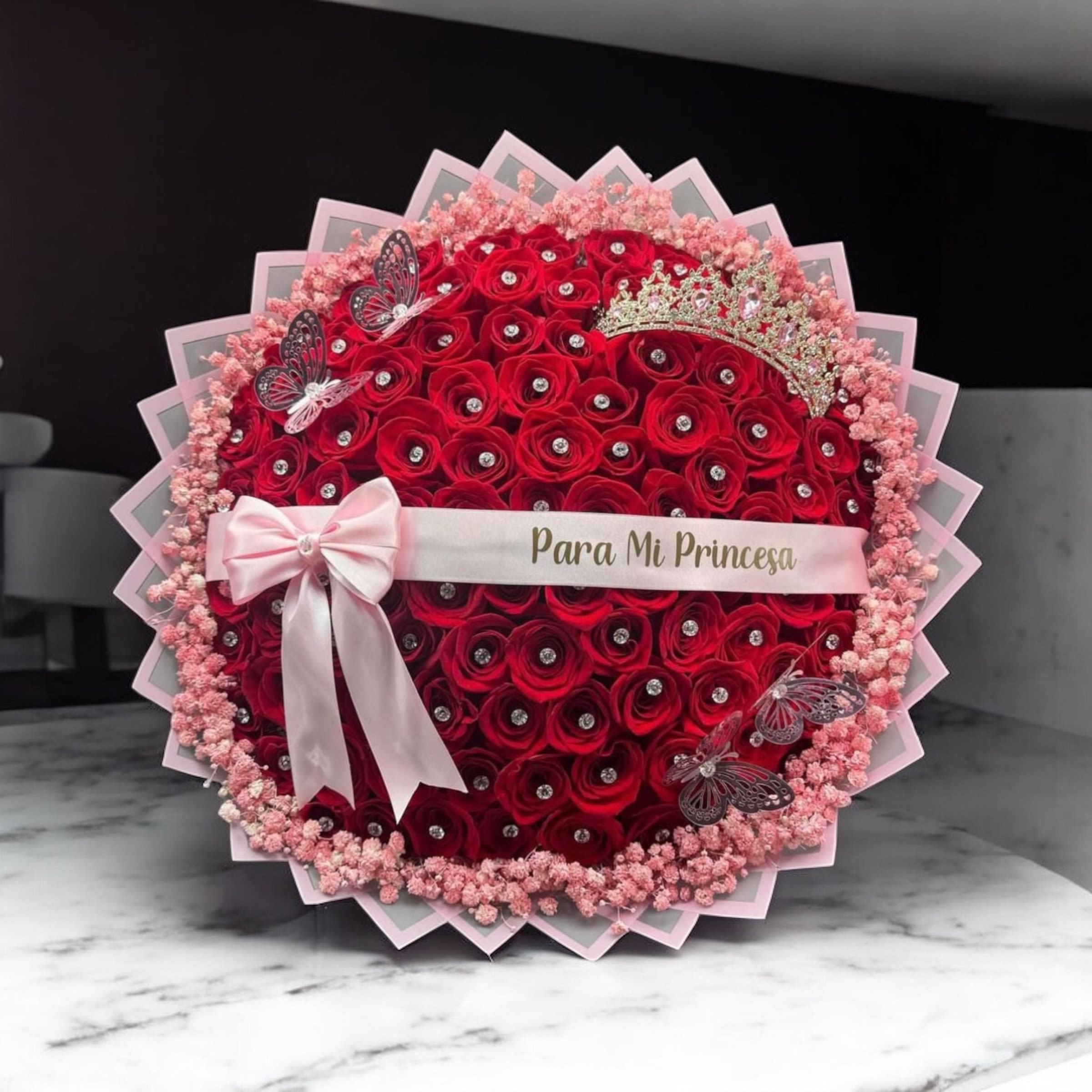 buchon para mi princesa - bouquet of 100 red roses, with pink gypsophila, ribbon with a phrase in Spanish or English, large crown, plastic butterflies, and fake diamonds. If you want a different color than the one in the photo, you can leave a note when you have placed the order. If we have the requested color, we will let you know with a message to your phone or email. If not, we will send you the color which is the red color requested on this page.