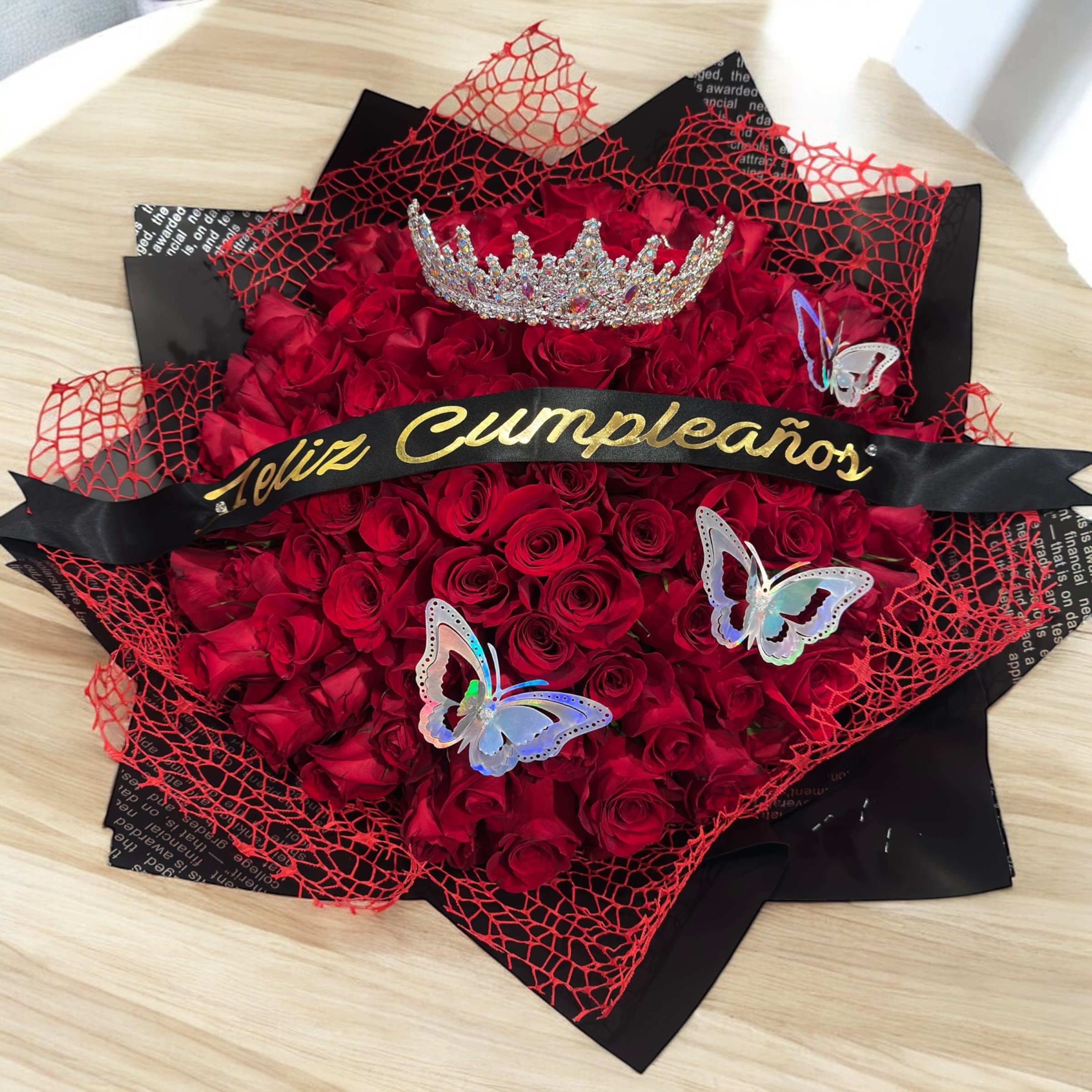 happy birthday - beautiful bouquet of 100 red roses to give to that friend, girlfriend, wife, or any special person, with a ribbon with a phrase in Spanish or English, princess crown as decoration and butterflies