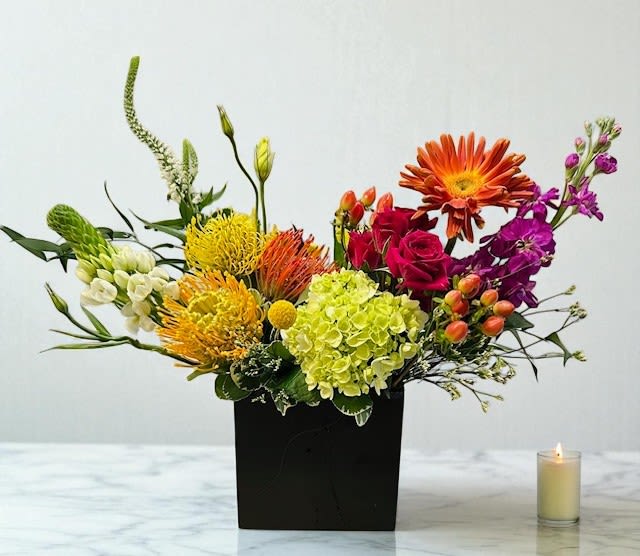 Summer Radiance - A bold and joyful burst of color, this arrangement captures the energy of summer with bright, sun-kissed blooms and lively textures. Designed to lift the spirit and bring warmth to any space or occasion.  Each piece is custom-made using fresh, seasonal flowers. Vase or container may vary.