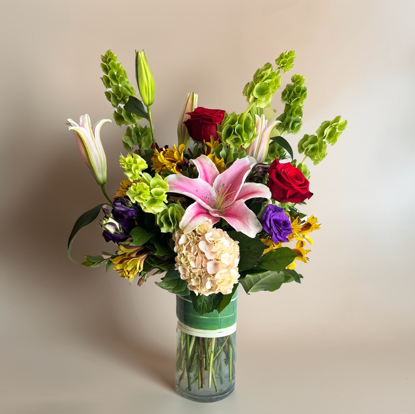 Lush Garden Lush Garden - "Lush Garden" is a captivating floral arrangement that seamlessly melds the timeless beauty of hydrangeas, the delicate elegance of roses, the exquisite allure of lisianthus, and the exotic grace of Bell of Ireland. Each component contributes to a symphony of colors, shapes, and fragrances that evoke a sense of enchantment and wonder.