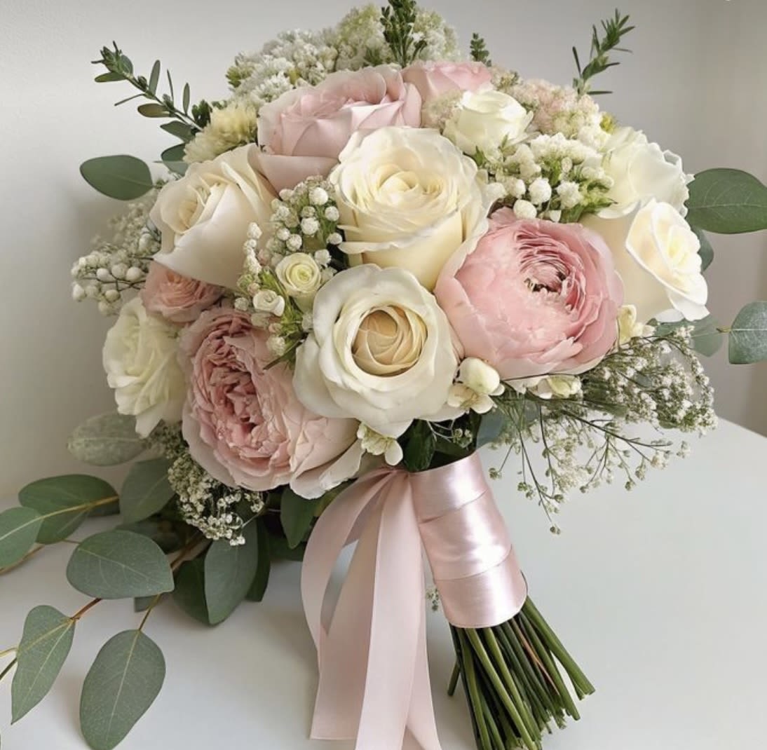 Silk Petal Silk Petal - A tender composition of blush, cream, and ivory roses, Silk Petal exudes softness and grace. Accented with delicate baby's breath and wrapped in satin ribbon, it’s a bouquet that speaks in whispers — perfect for romantic brides, elegant events, or simply saying "you’re beautiful.