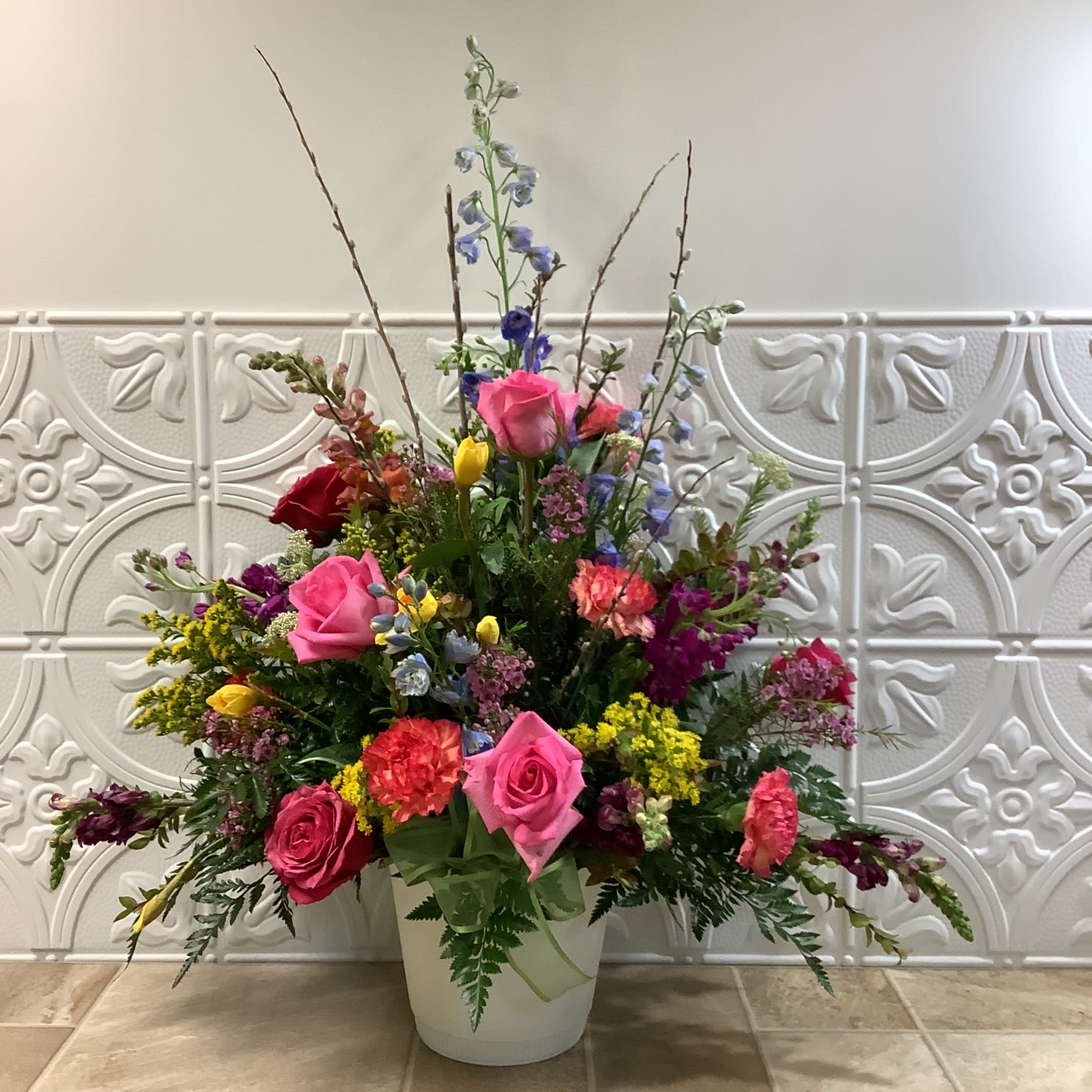 Garden Style Bouquet Garden Style Bouquet - Honor someone special with this abundant bouquet filled with a burst of colorful blooms, including pink roses and carnations, orange snapdragons, purple stock, and blue delphinium. Ferns and other assorted greenery and pussy willow stems add height and a lush, full look. Primary flowers: rose, carnation, snapdragon