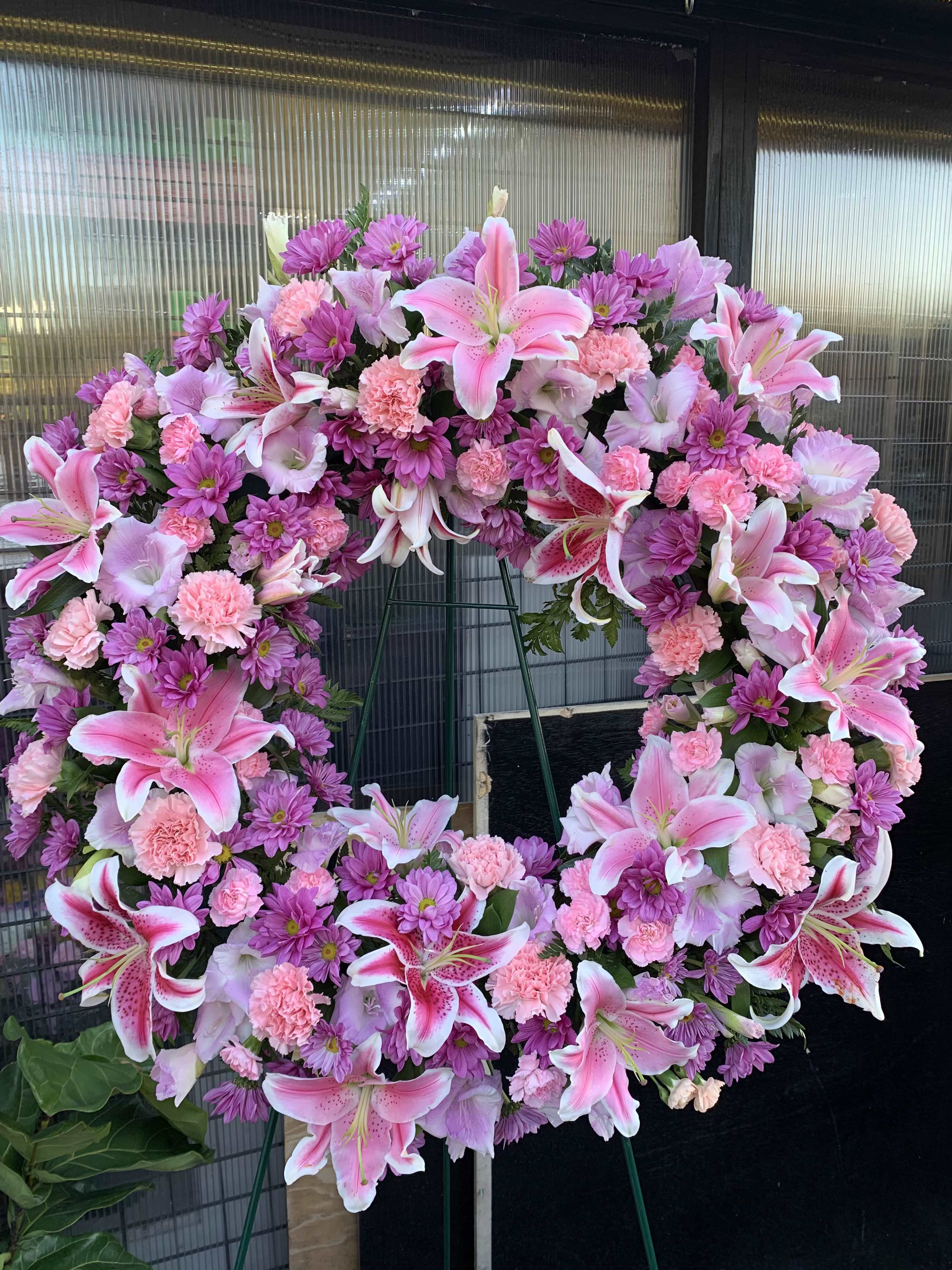 Purple and Pink Wreath - This funeral arrangement serves as a beautiful tribute, offering solace and expressing the beauty of a life well lived. 