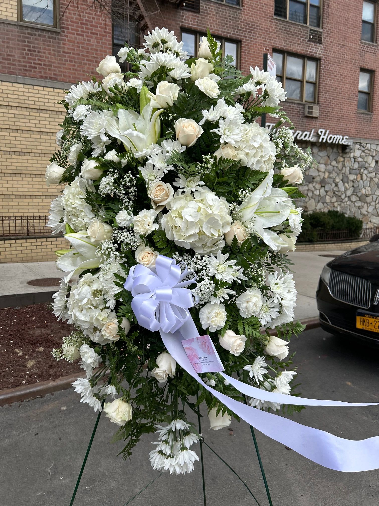 Purity Standing Spray - The purity standing spray is a breathtaking and deeply serene funeral arrangement, designed to convey a message of peace, innocence, and heartfelt remembrance. 