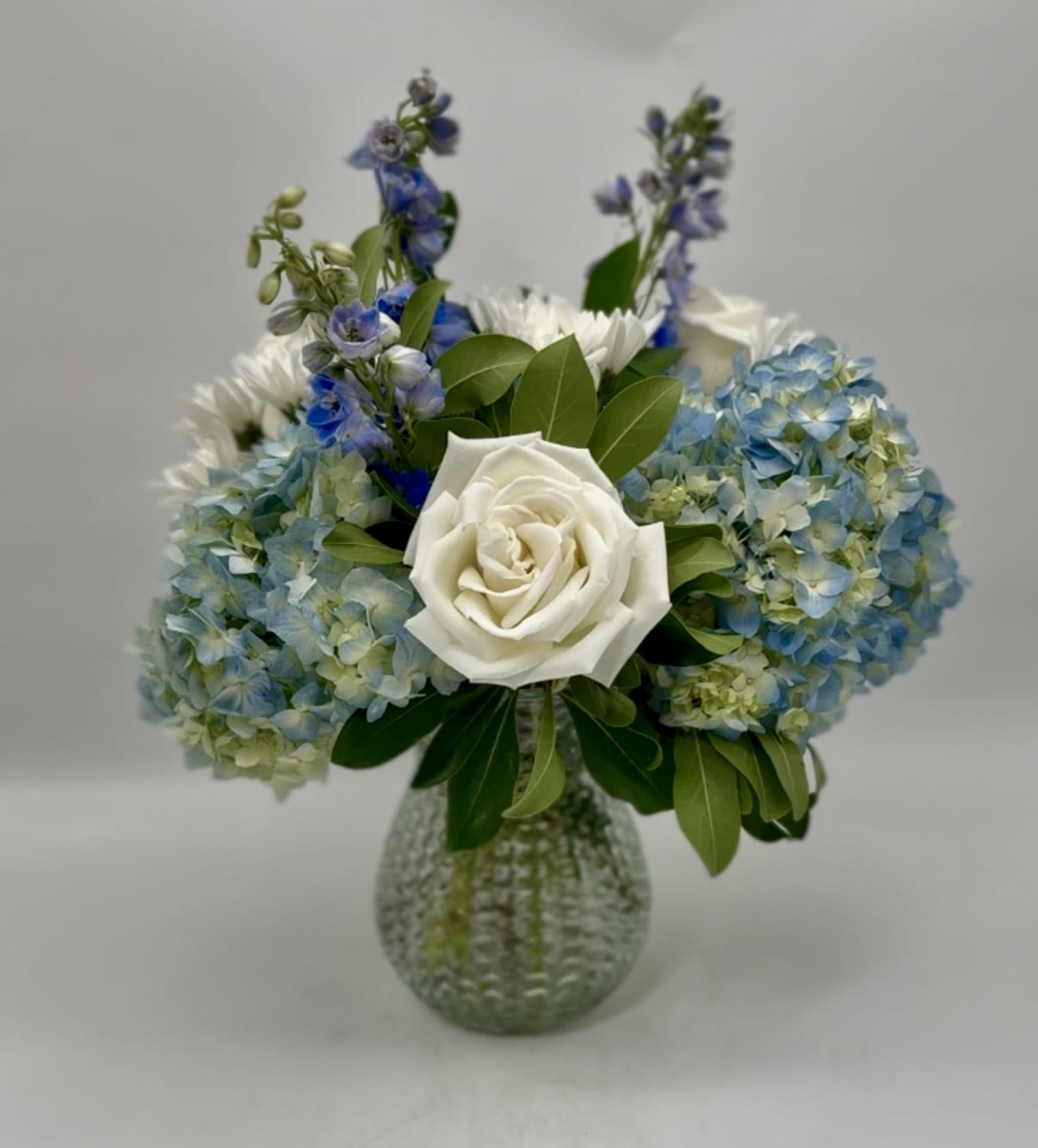 Blue Skies Over Charleston - Send a bit of the beautiful blue skies to convey your feelings.  This uplifting arrangement comes in a beautiful mix of blue and white.  The vase may vary but the arrangement will be similar to photo.