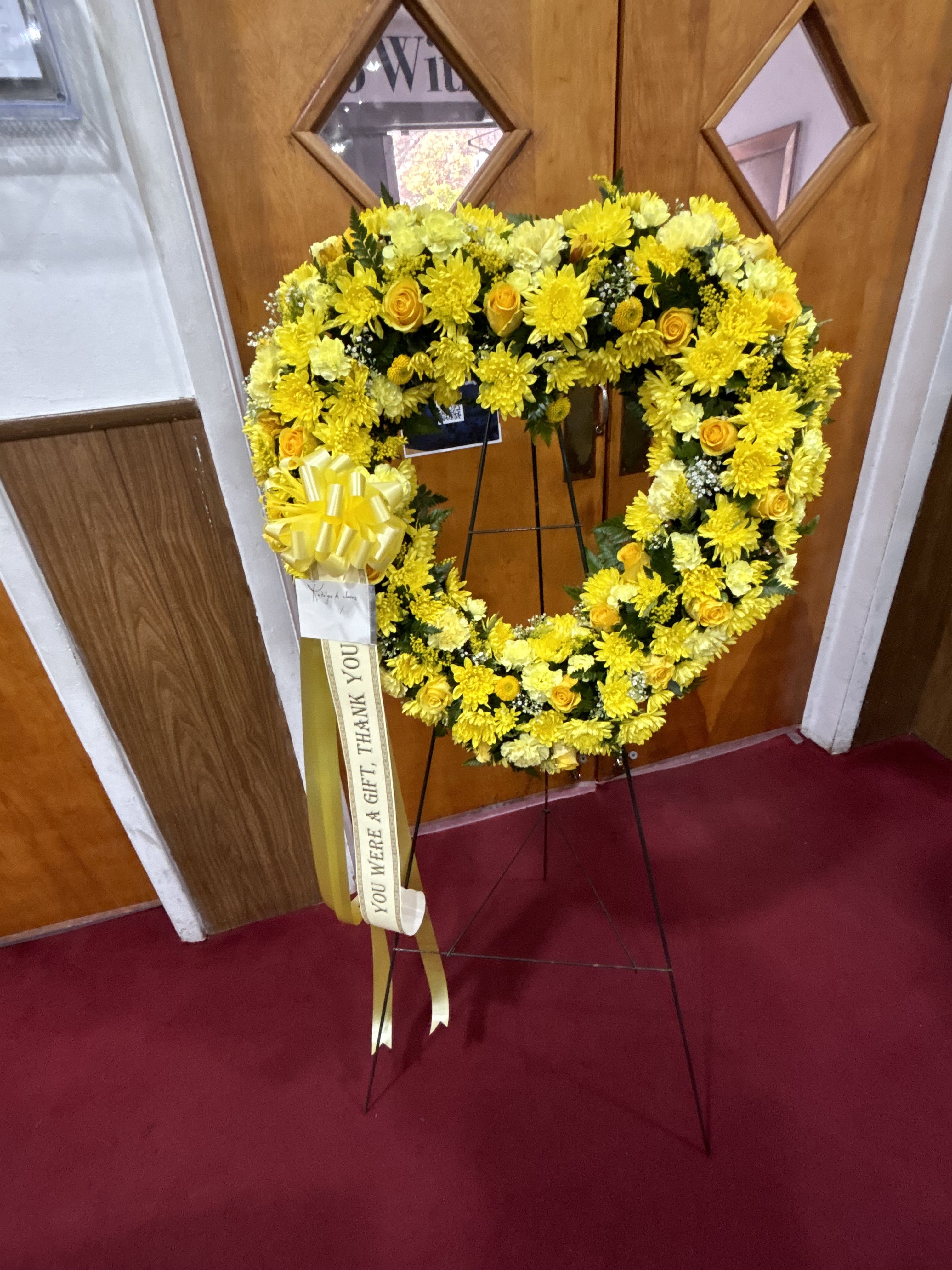 A Yellow Open Heart - The Yellow Open Heart is a warm and tender funeral arrangement, beautifully designed to convey heartfelt sympathy, and a gentle celebration of a life filled with light. 