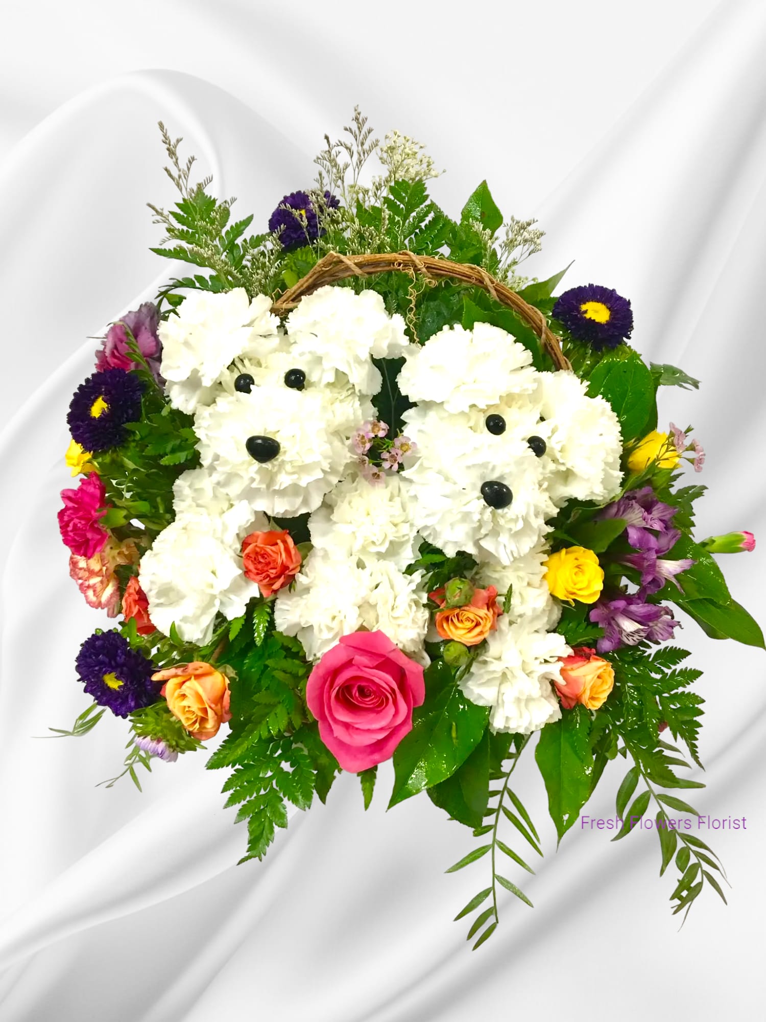 Puppy Bloom - Introducing our delightful floral creation - a charming arrangement reminiscent of an adorable puppy dog, artfully crafted with fluffy carnations in a variety of hues. Surrounding this whimsical centerpiece are a vibrant assortment of different flowers and colors, adding a playful touch to your space. Perfect for dog lovers and flower enthusiasts alike, this unique arrangement brings joy and beauty into any room. Bring home a touch of whimsy with our Puppy dog floral creation today!