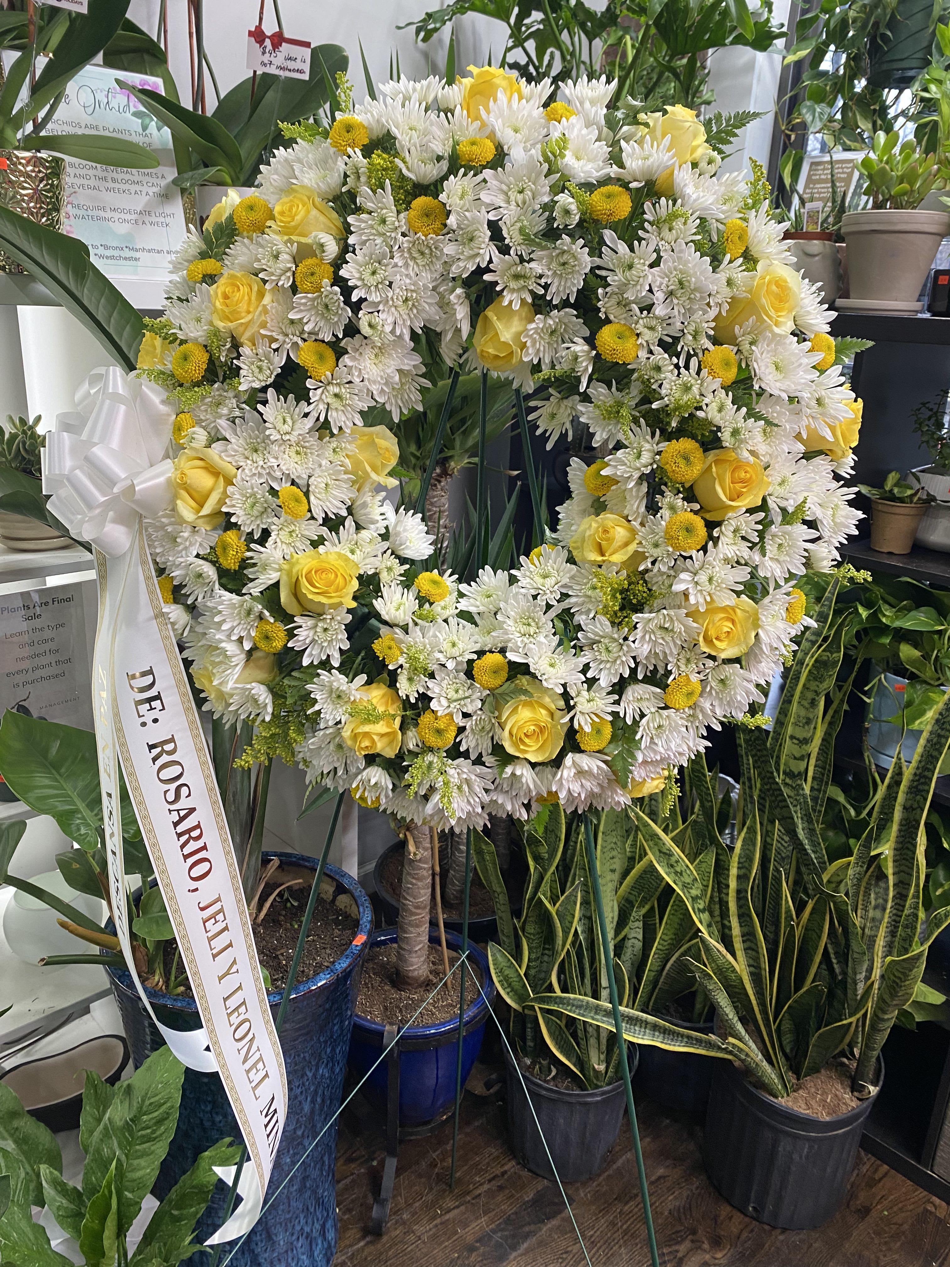 Wreath in Yellow - The Wreath in Yellow is a radiant and deeply heartfelt funeral arrangement, designed to convey warmth, remembrance, and the bright light of a spirit well lived. The yellow flowers symbolize friendship, joy, and profound respect. 