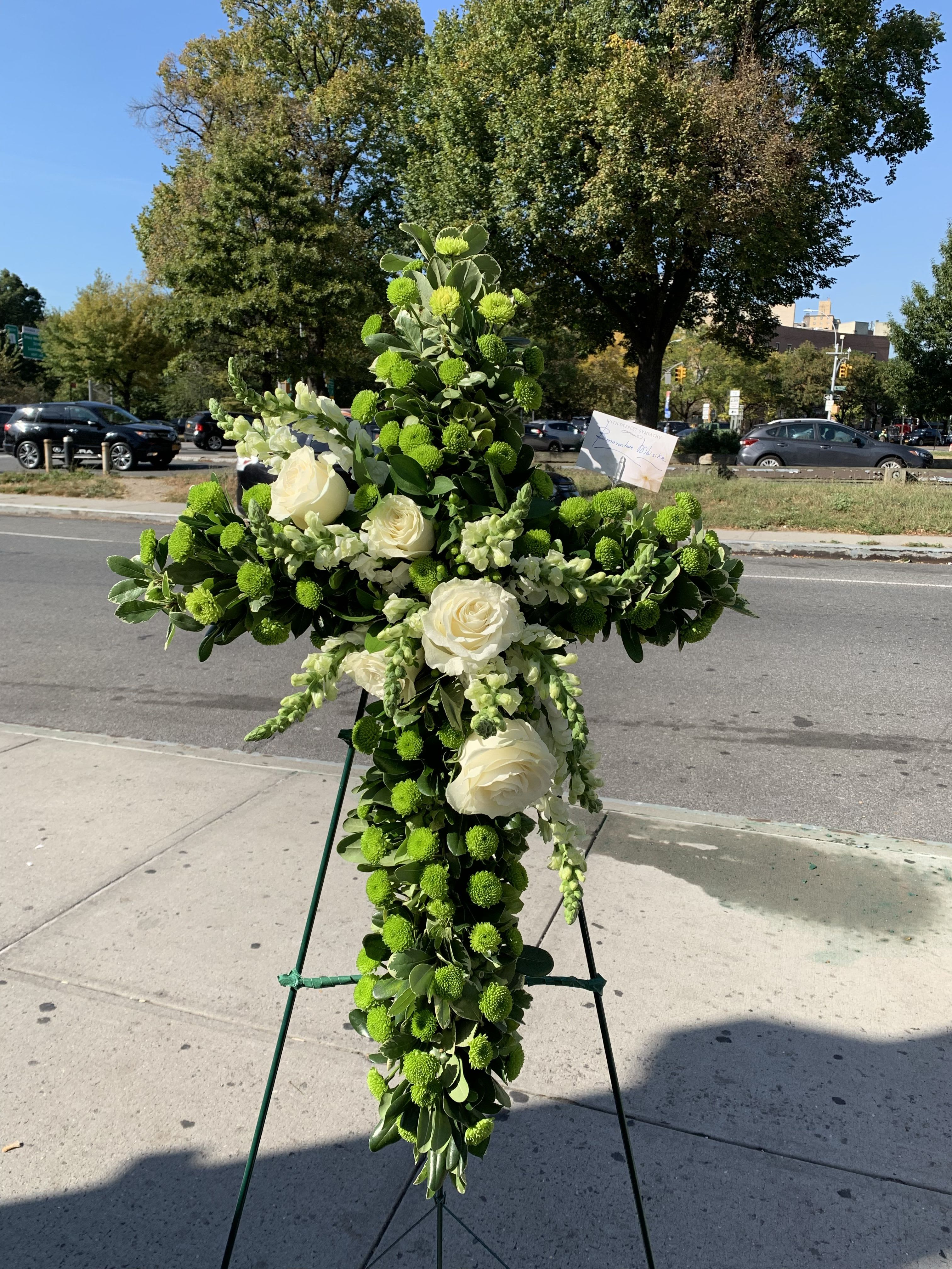 Broken Green Cross - The Broken Green Cross is a deeply symbolic and poignant funeral arrangement, thoughtfully designed to convey profound grief, enduring faith, and a respectful farewell