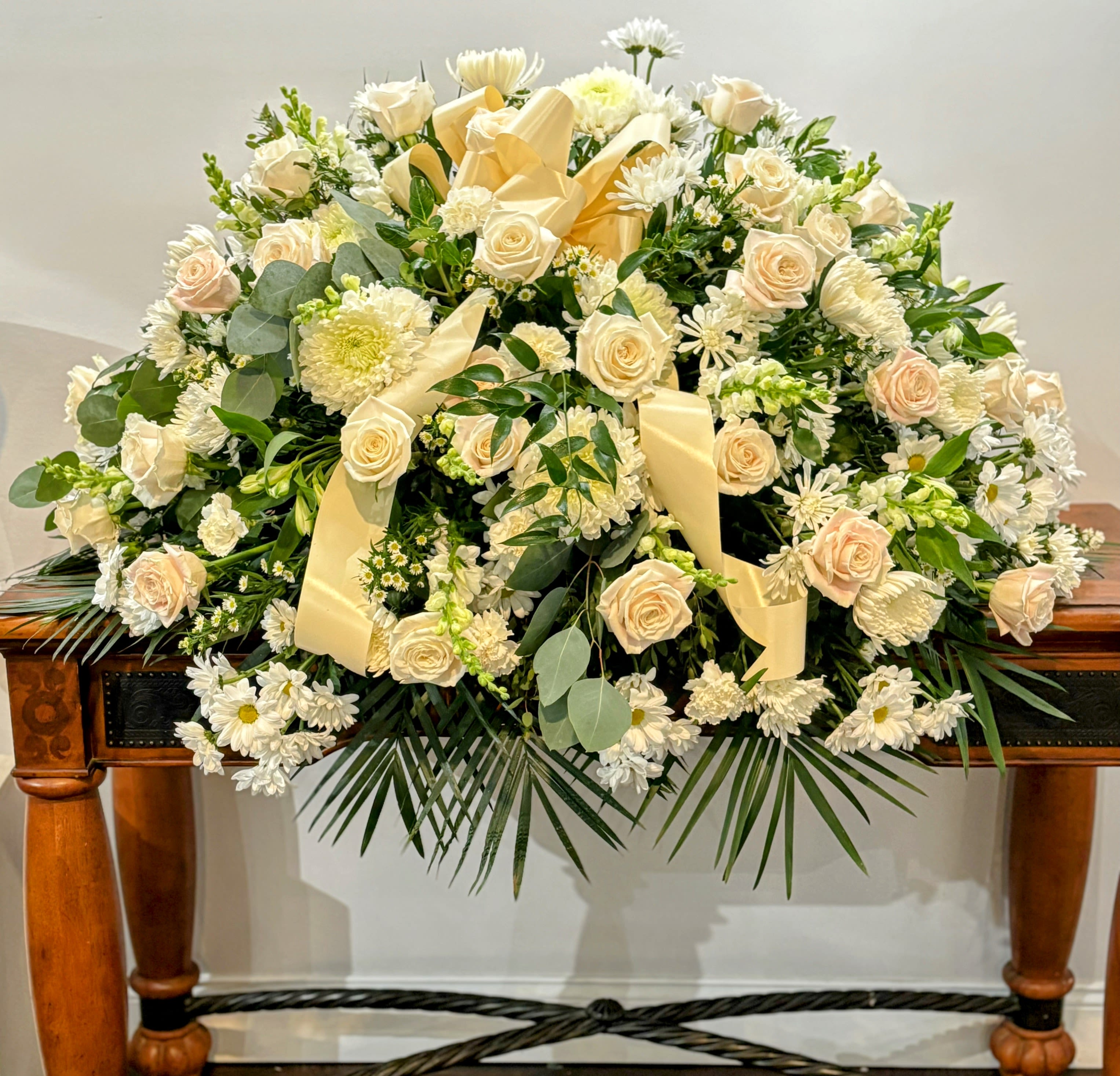 Casket Piece - Bursting with a wide variety of cream &amp; white flowers to show our respect for the loved lost too soon, and yellow chrysanthemums for happy memories relived together. Contact the store for customization.