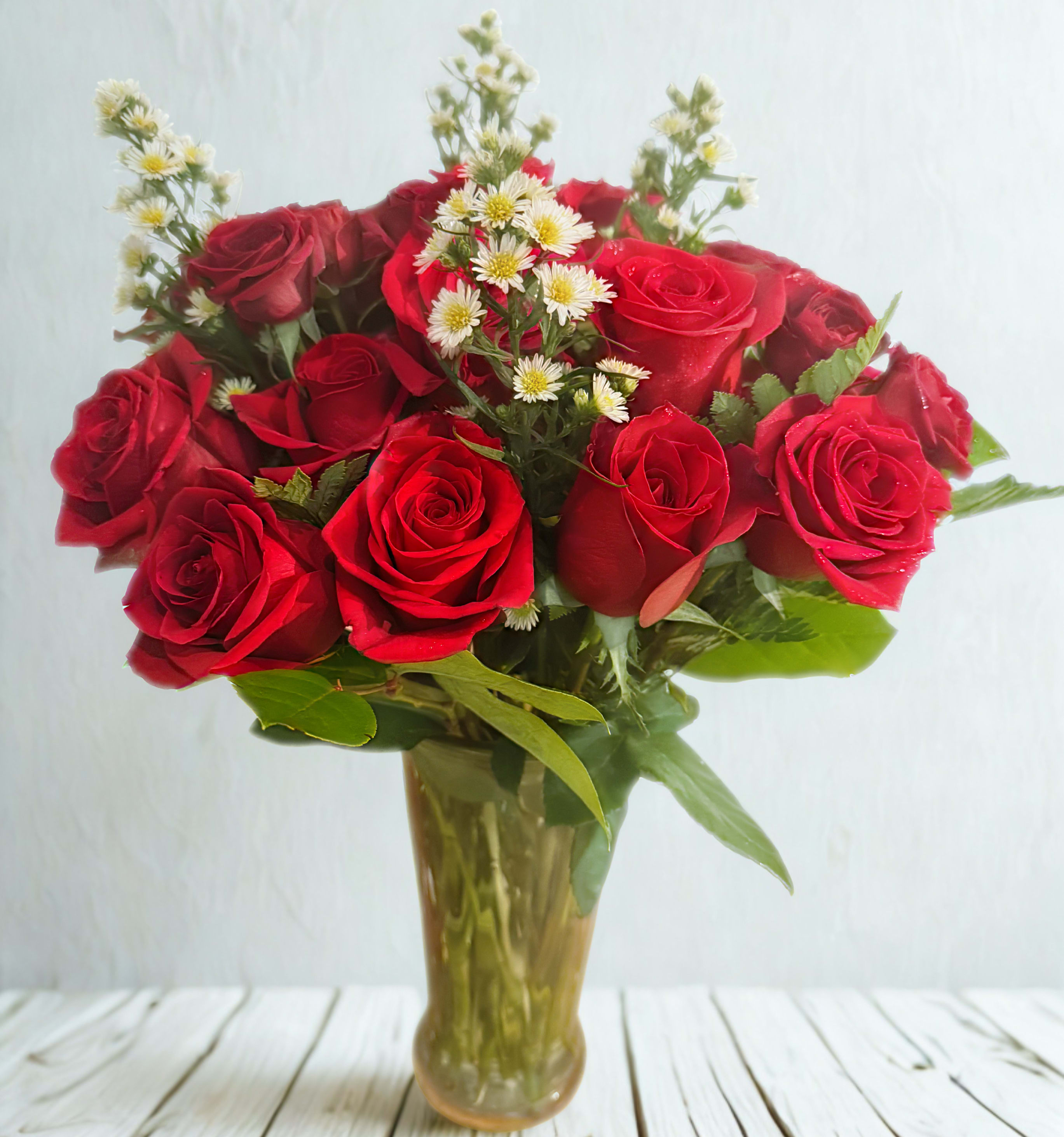 Rosy Radiance - A classic bouquet of 2 dosen vibrant red roses paired with delicate white filler, arranged in a glass vase. Timeless, elegant, and full of love.