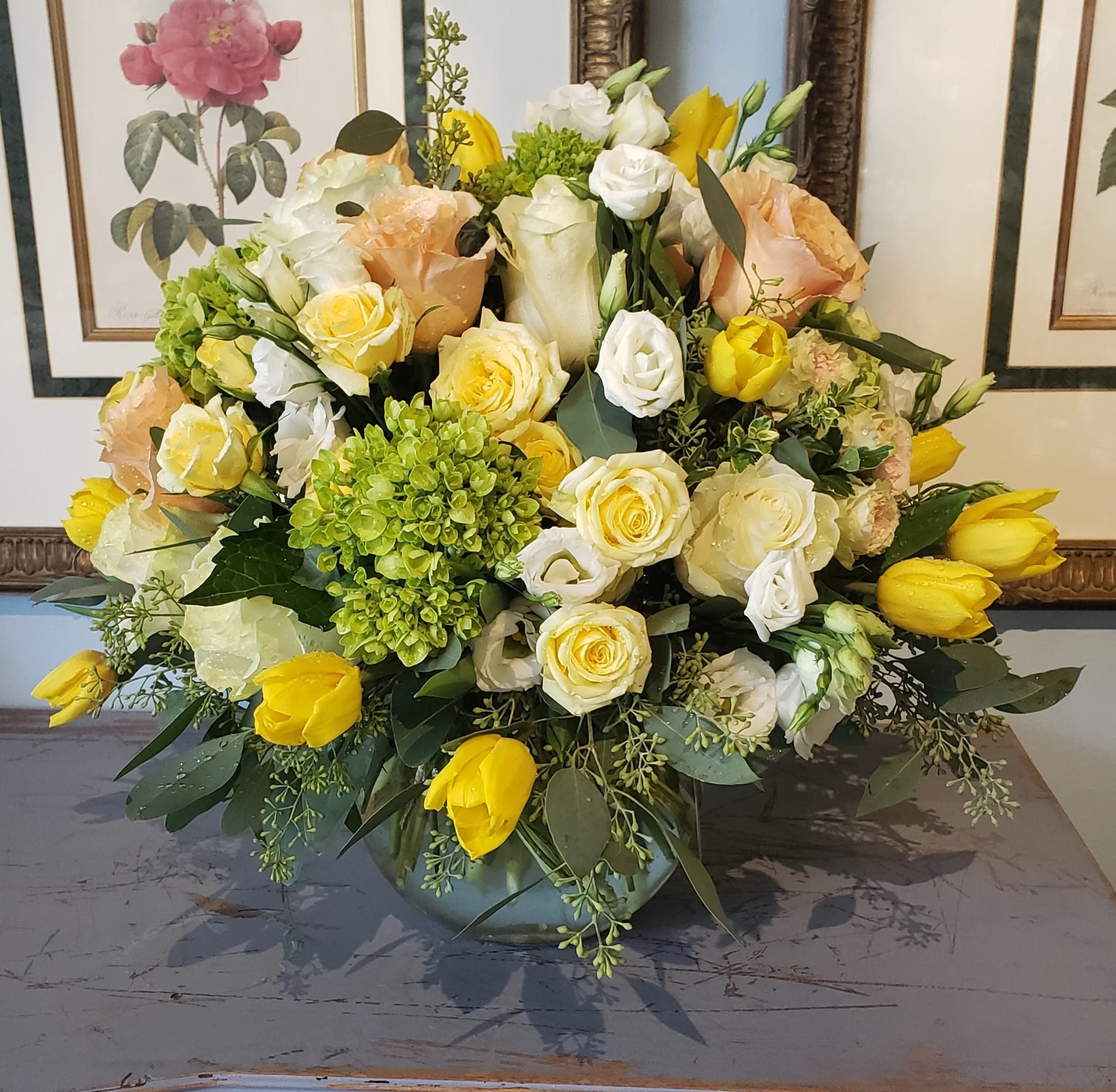 Lemon Squeeze  - Lemon Squeeze brings a burst of sunshine into any space with its vibrant blend of perry green mini hydrangea blooms, gorgeous peach roses, butterscotch yellow and white spray roses, cheerful yellow tulips, and fresh white lisianthus. Seeded eucalyptus complements the arrangement, creating a lively and elegant display in a clear glass bubble bowl.  Please note: Flowers and vase may vary depending on availability, ensuring each arrangement is fresh and unique.  Freshness Guarantee: At Belden's Florist, we stand behind the quality of our products. Our flowers are guaranteed to remain fresh and beautiful for 3–5 days after delivery. While cut flowers may naturally start to wilt beyond this timeframe, we ensure that you receive the freshest blooms possible, carefully selected and expertly arranged to bring joy and elegance to your space. To help your flowers stay fresher longer, we recommend adding fresh water to the vase regularly. Just like you, flowers need hydration to thrive, and refreshing the water allows them to drink up and continue to dazzle you with their beauty.