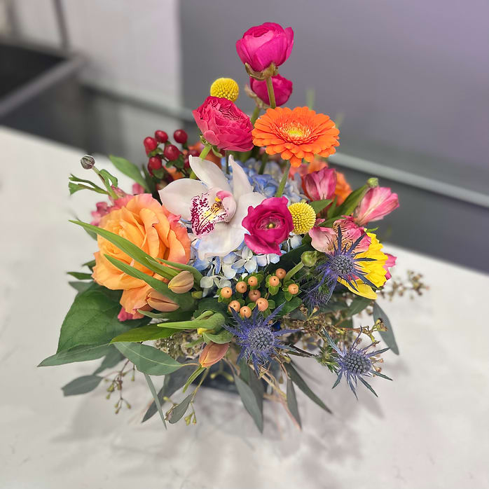 Just Because You're Pretty - A playful gathering of vibrant blooms—gerbera daisies, ranunculus, blue thistle, and golden fillers—“Jus Because You're Pretty” is a party in a vase. It’s made for the spontaneous, the playful, the endlessly optimistic. Whether it’s a birthday, a cheer-up, or a “just because,” this bouquet says: life is beautiful, don’t forget it.  Send when you want to brighten someone’s whole week.