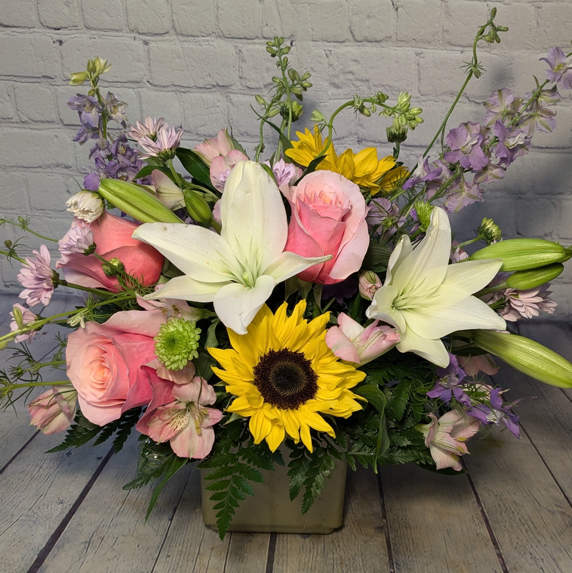 Fairy Tale - Make today a fairy tale with this whimsical and colorful bouquet of lilies, roses, larkspur, and sunflowers. 