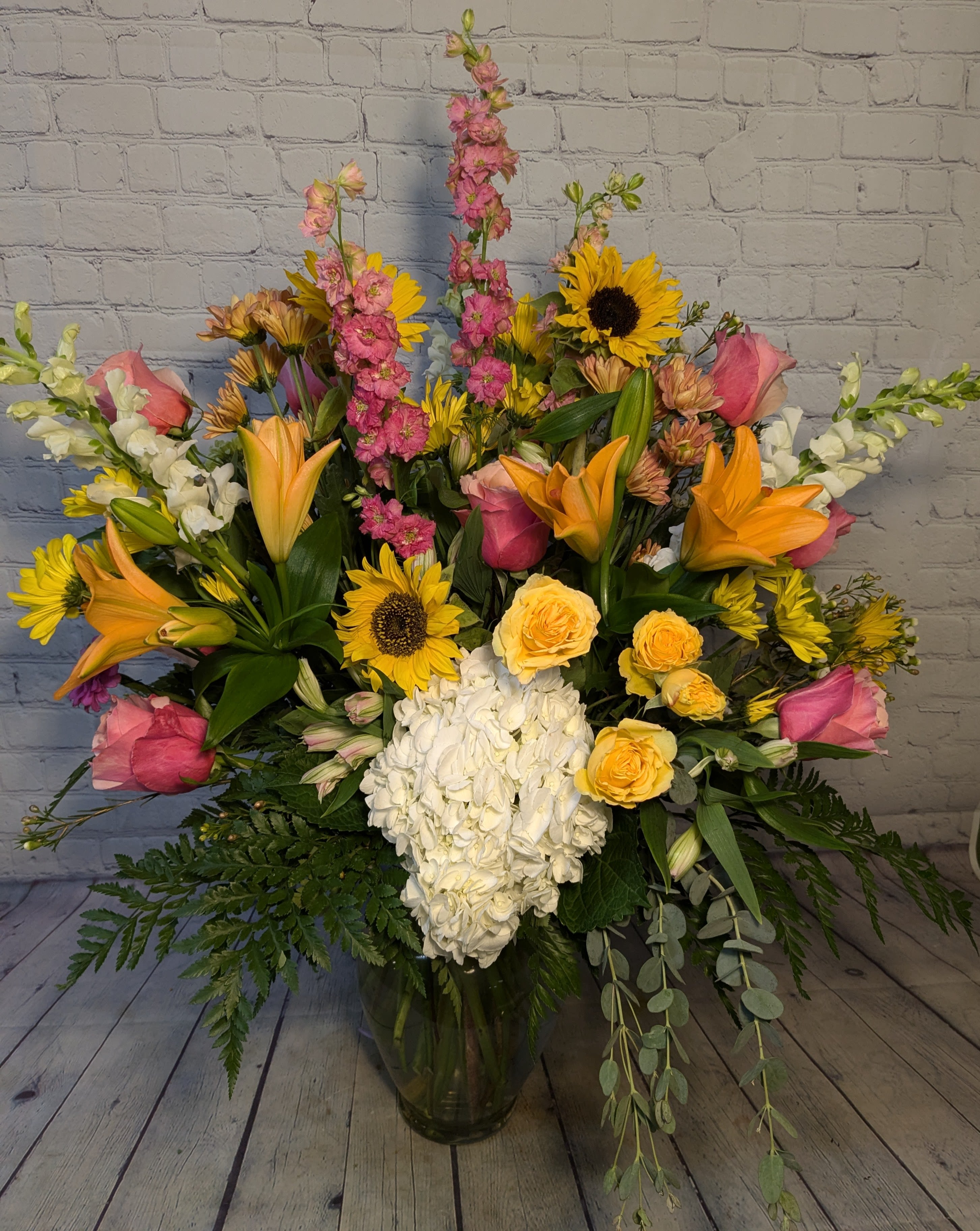 Sunset - Sunset colors and sweet summer flowers are hand arranged in this large vase arrangement. 