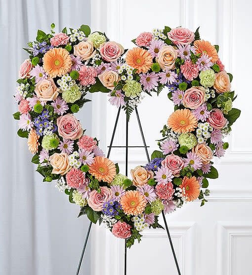 Pastel Open Heart (FH10) Pastel Open Heart (FH10) - Open, heart-shaped arrangement of pink and peach roses; pink and lime green carnations; peach Gerbera daisies; purple and white monte casino; accented with baby’s breath and soft, lush greenery