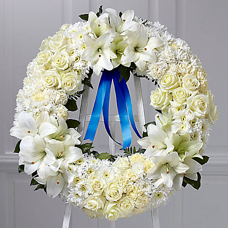 Remembrance Wreath Blue Ribbon(FW14) Remembrance Wreath Blue Ribbon(FW14) - White roses, carnations and Asiatic lilies complemented by lush greens and blue satin ribbon and trim.